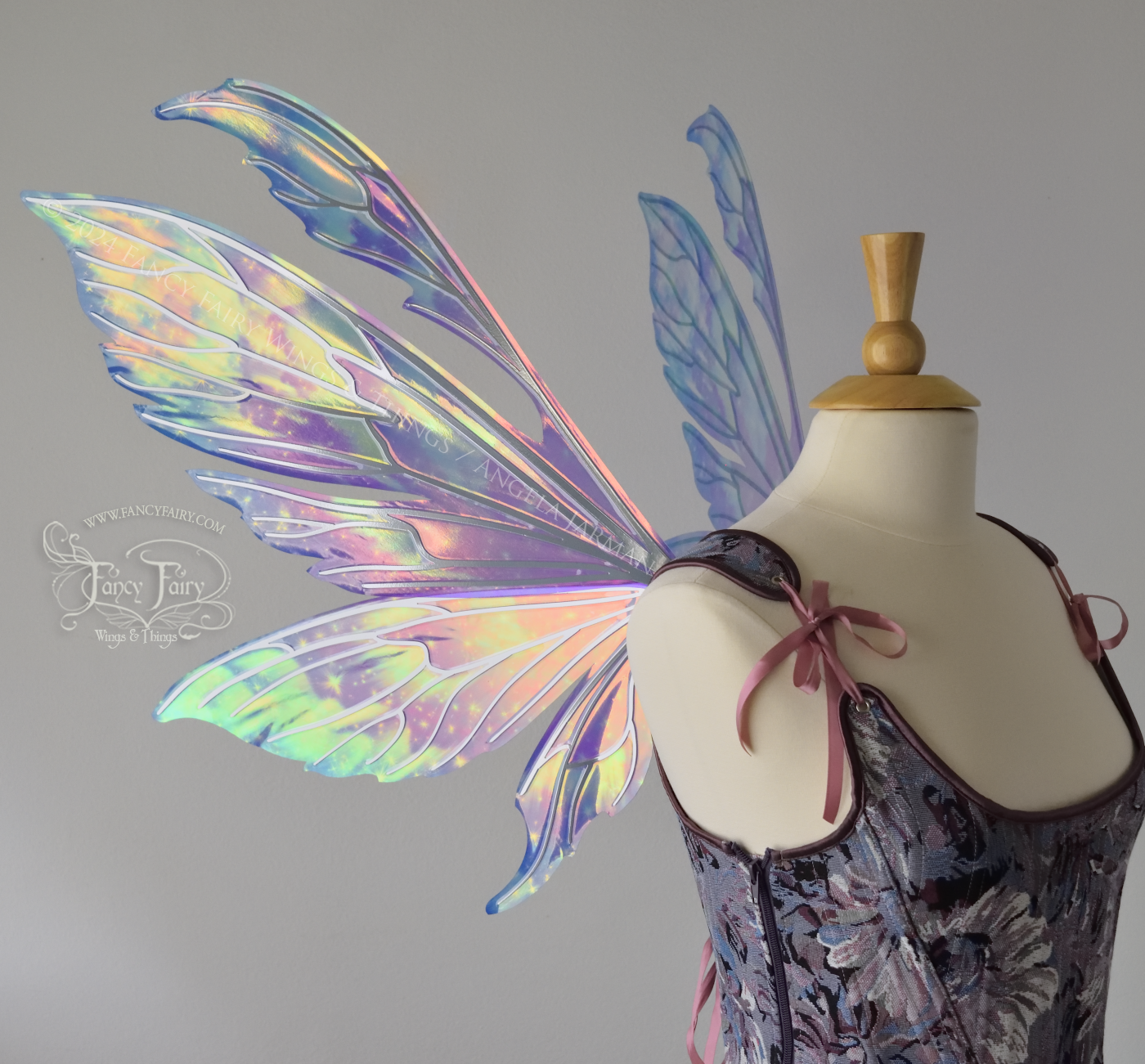 Iridescent fairy wings with pointed tips & antennae, painted with auroras & stars in pinks, purples & blues, with silver veins, left side view