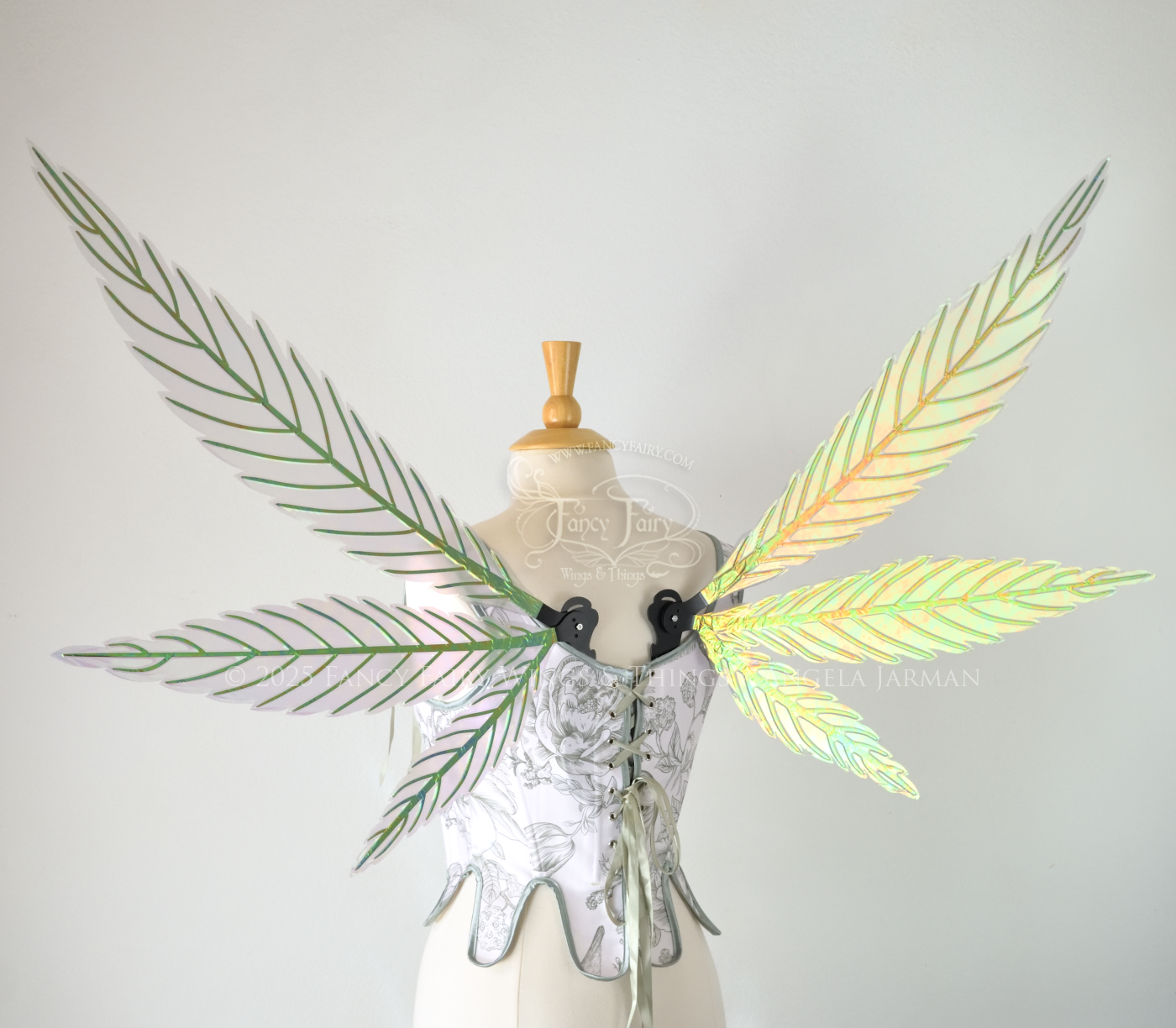 Green iridescent fairy wings styled after hemp leaves with black veins, worn on a dress form, back view