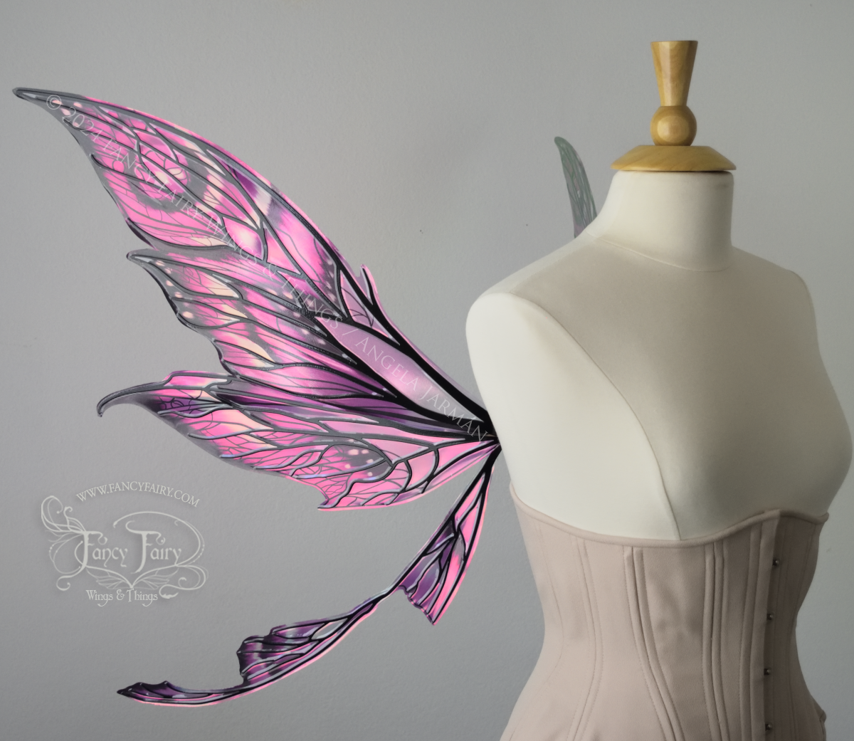 Left side view of pointy tipped pink & black iridescent wings in with black detailed veins, worn on a dressform