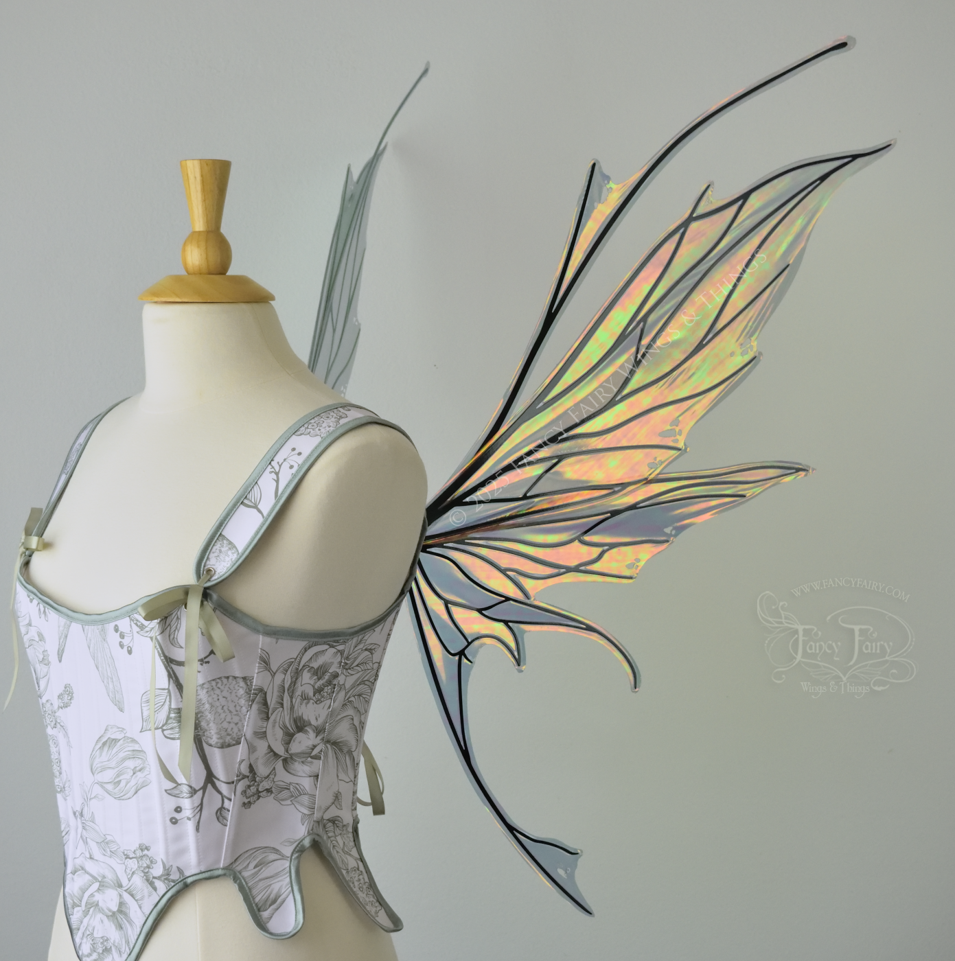 Large orange / green iridescent fairy wings featuring antennae along the top and a spikey profile, worn on a dress form, right side view