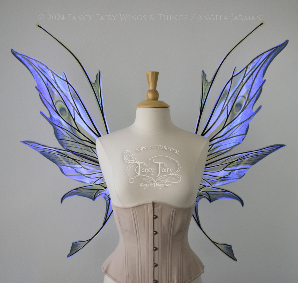 Front view of large spikey blue painted iridescent fairy wings with antennae along the top & black detailed veins, displayed on dress form. Bottom panels have tails.