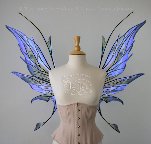 Front view of large spikey blue painted iridescent fairy wings with antennae along the top & black detailed veins, displayed on dress form. Bottom panels have tails. 