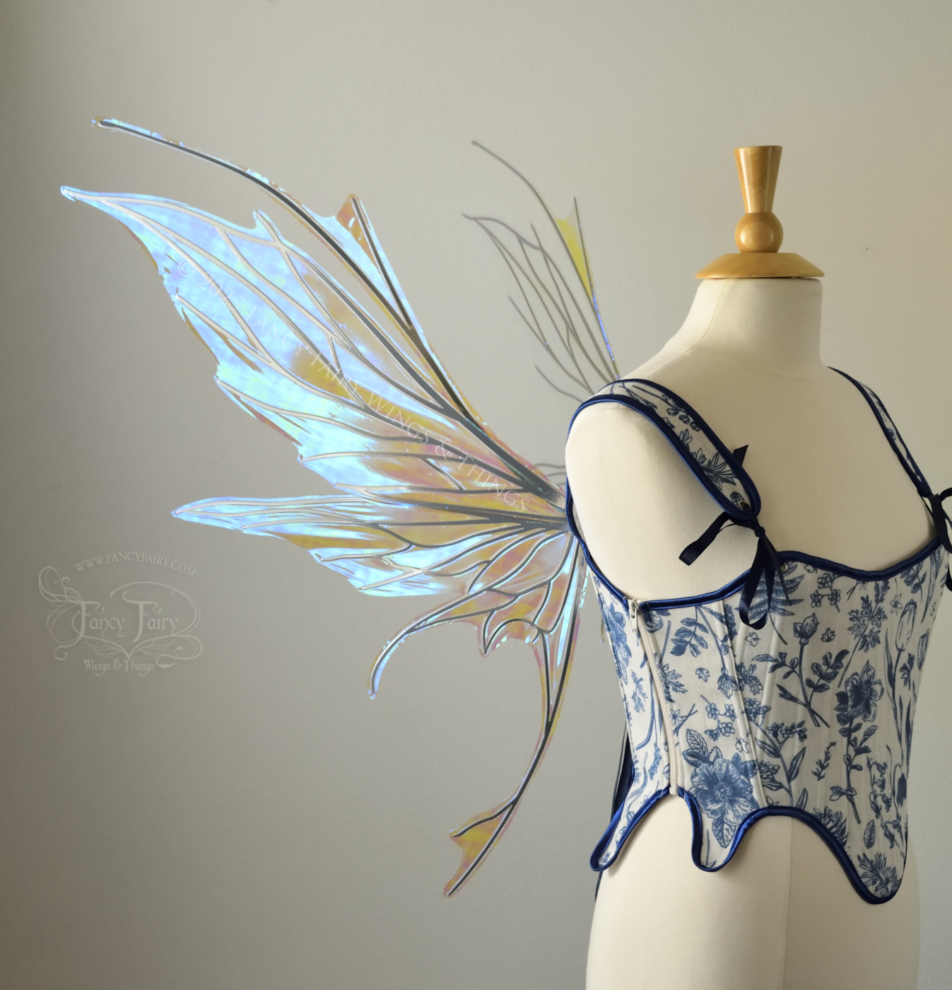 Large blue / green iridescent fairy wings with silver veins featuring antennae along the top and a spikey profile, worn on a dress form, left side view