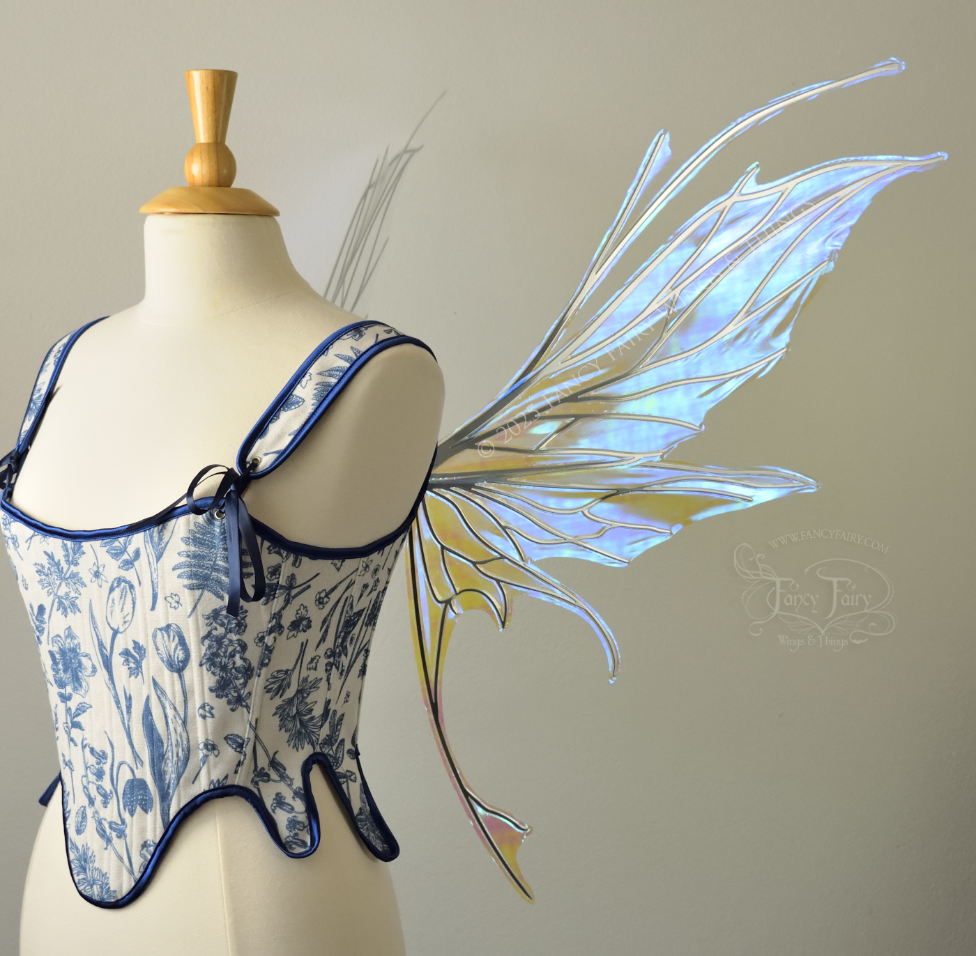 Large blue / green iridescent fairy wings with silver veins featuring antennae along the top and a spikey profile, worn on a dress form, right side view
