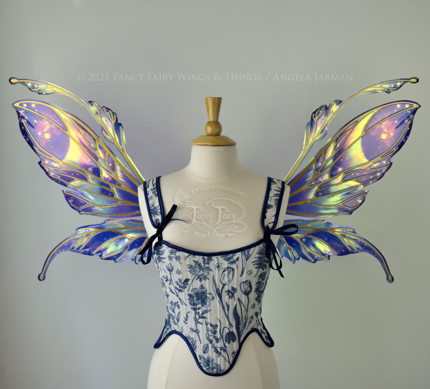 Iridescent fairy wings with a spacey night sky painted on them, with auroras, nebulae and stars, with gold veins & antennae, worn on a dress form, front view.