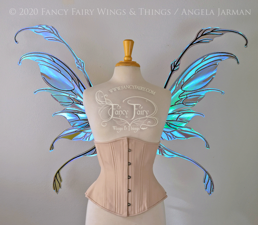 Front view of a dress form wearing an underbust corset & 'Fauna' transparent purple / blue iridescent fairy wings with downward curved tips, antennae & wispy 'tails', with black veining