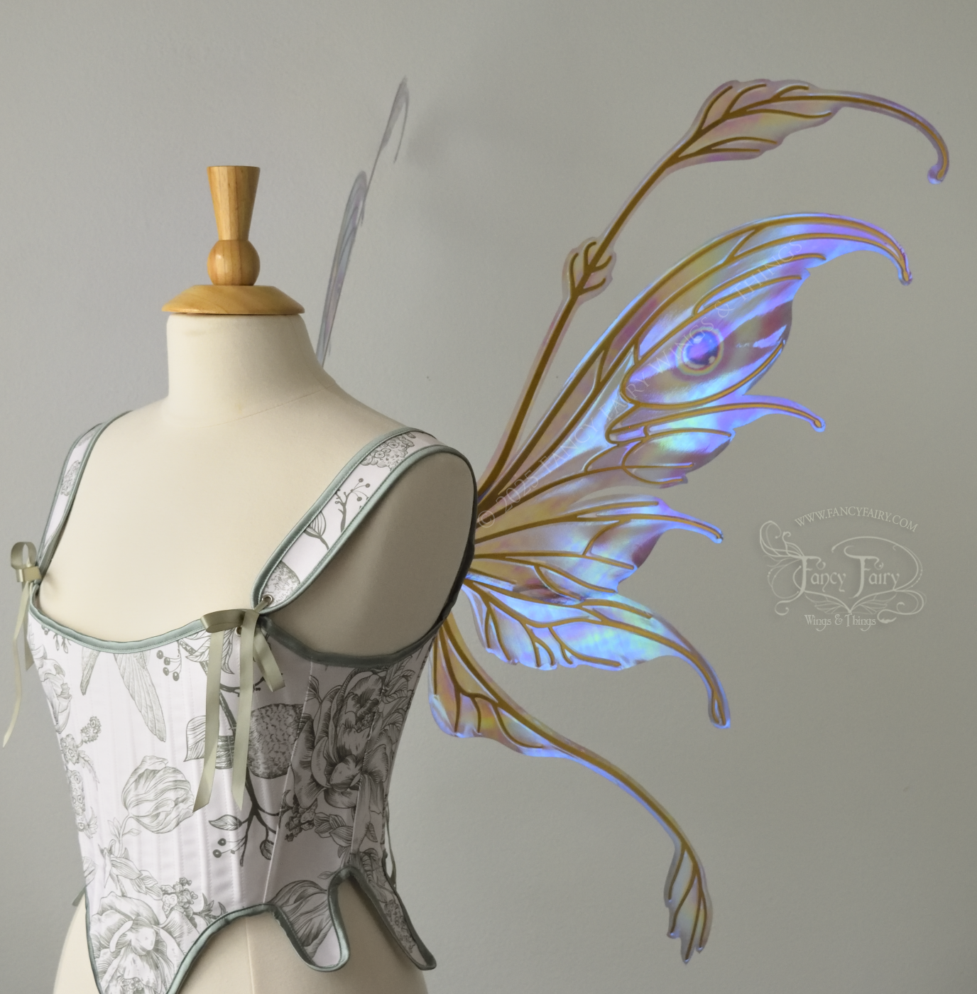 Iridescent pastel rainbow fairy wings with downward curved tips, antennae and appendages, with gold veins, worn on a dress form, right side view