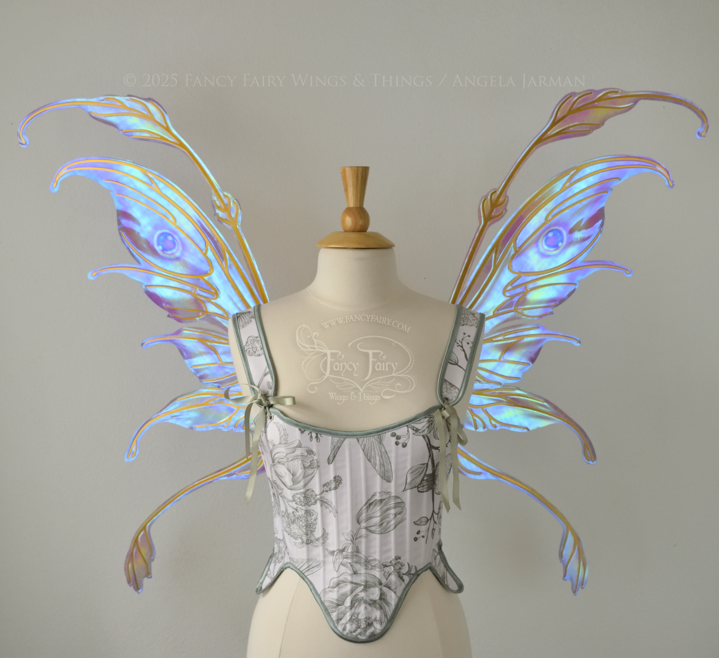 Iridescent pastel rainbow fairy wings with downward curved tips, antennae and appendages, with gold veins, worn on a dress form, front view