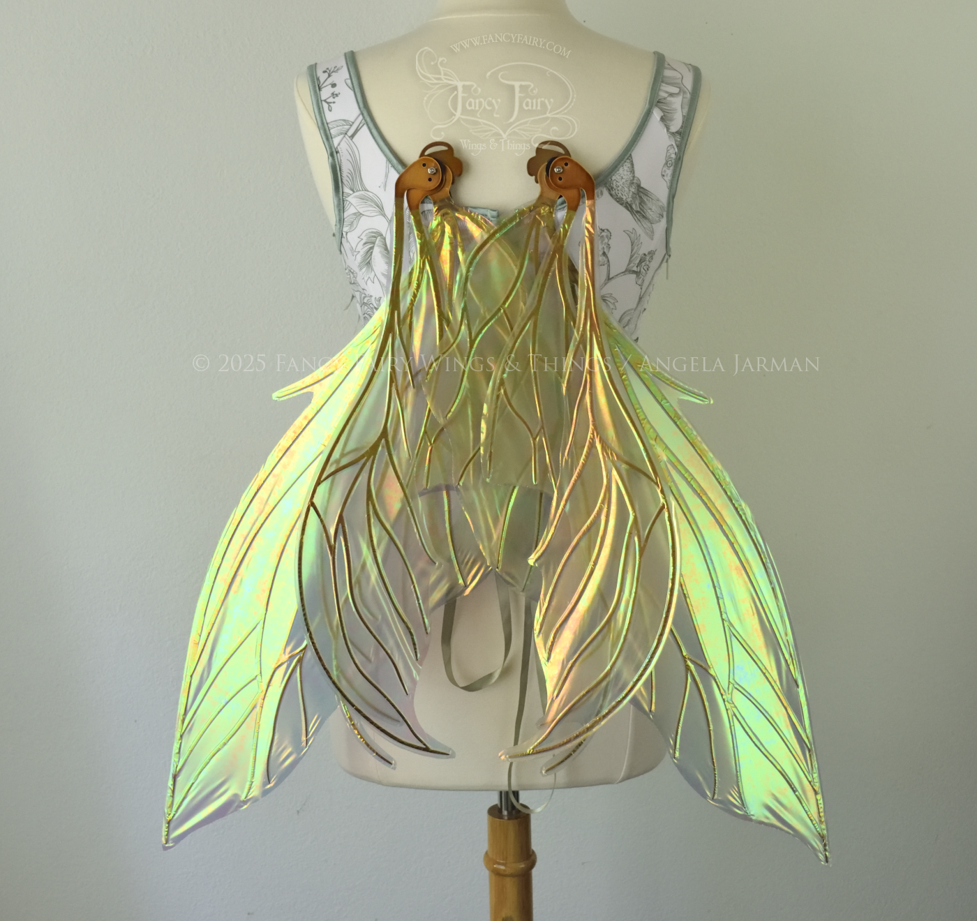 Large transparent iridescent orange/yellow/green dragonfly-like iridescent fairy wings with copper veins have 3 elongated panels on each side, worn on a dress form, back view, in resting position