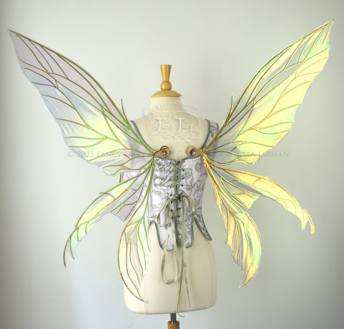Large transparent iridescent orange/yellow/green dragonfly-like iridescent fairy wings with copper veins have 3 elongated panels on each side, worn on a dress form, back view