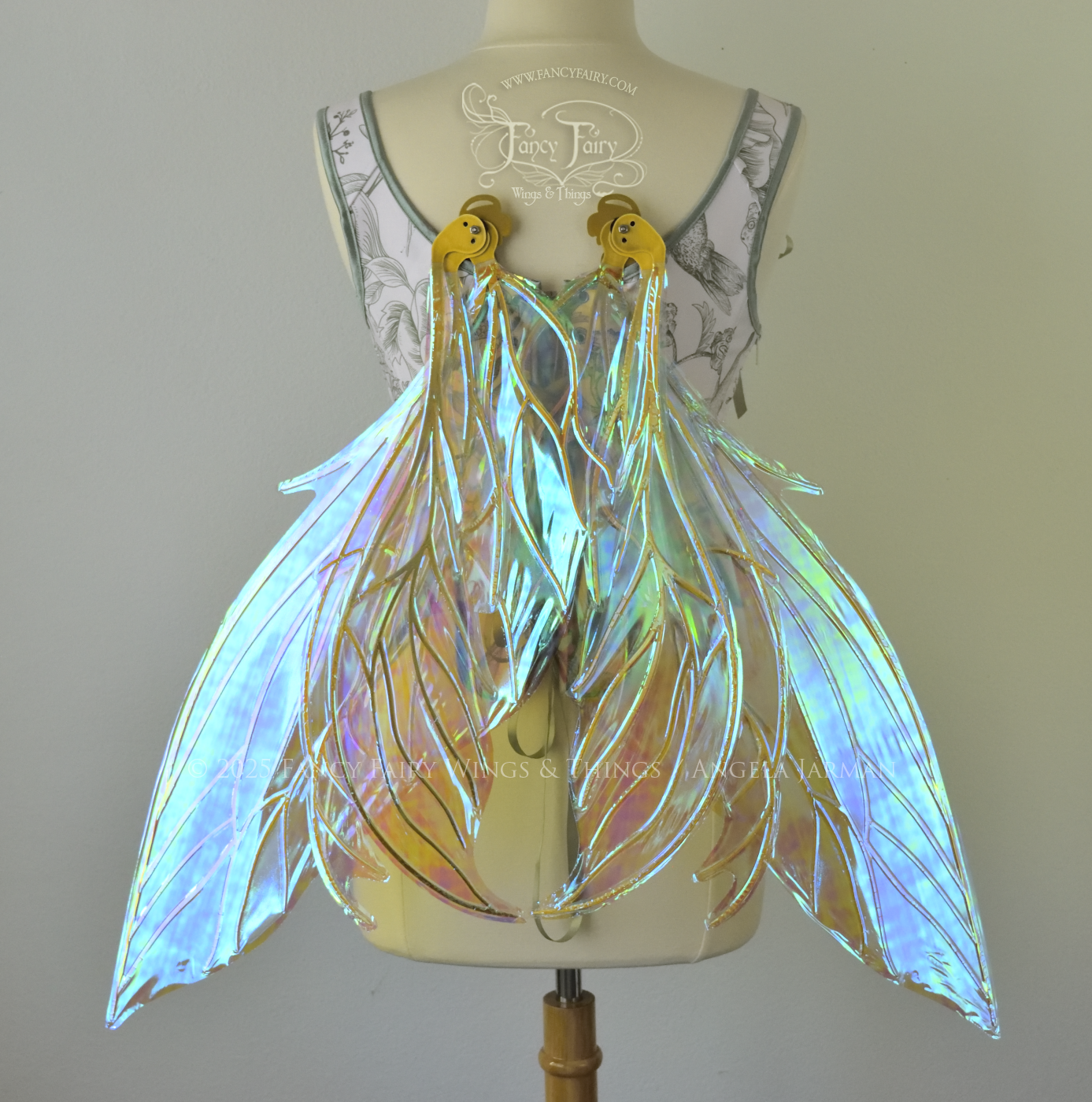Large transparent blue/green dragonfly-like iridescent fairy wings with gold veins have 3 elongated panels on each side, worn on a dress form, back view, in resting position