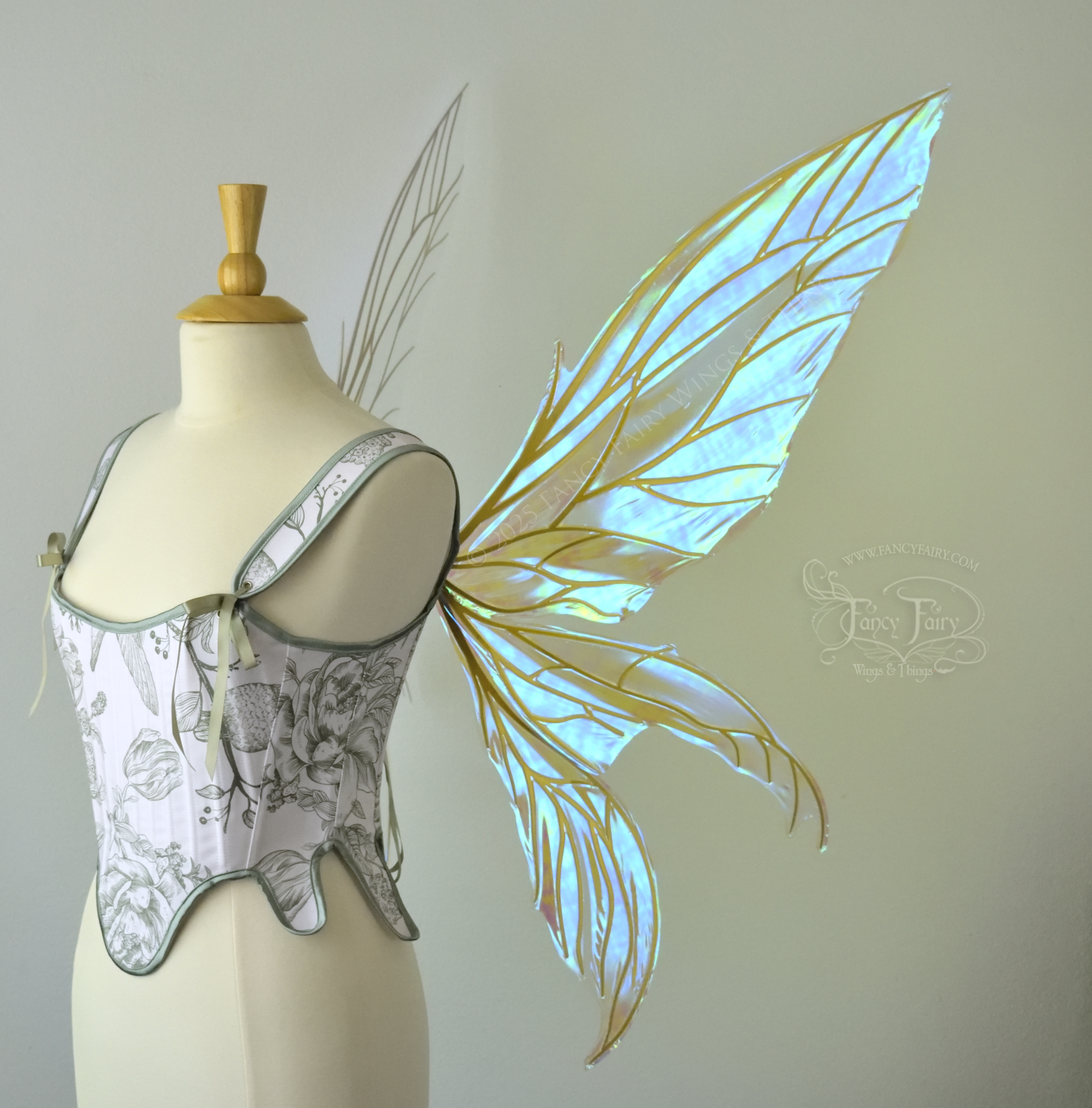 Large transparent blue/green dragonfly-like iridescent fairy wings with gold veins have 3 elongated panels on each side, worn on a dress form, right side view