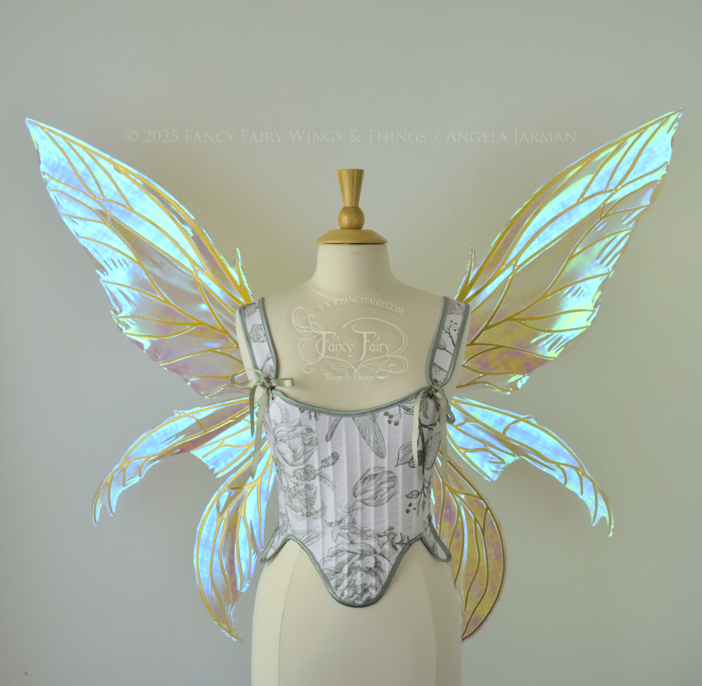 Large transparent blue/green dragonfly-like iridescent fairy wings with gold veins have 3 elongated panels on each side, worn on a dress form, front view