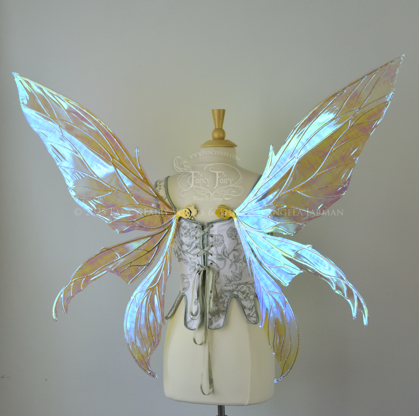 Large transparent blue/green dragonfly-like iridescent fairy wings with gold veins have 3 elongated panels on each side, worn on a dress form, back view