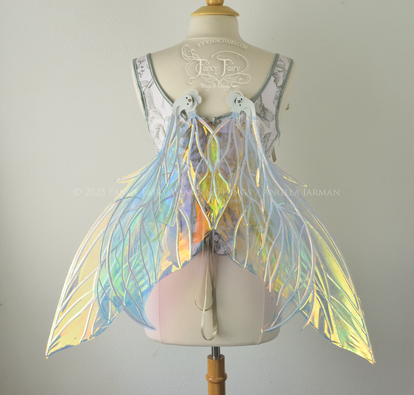 Large transparent yellow/orange/green iridescent fairy wings with white veins. Upper panels are elongated with pointed tips, 2 lower panels curve downward, worn on a dress form, back view in resting position