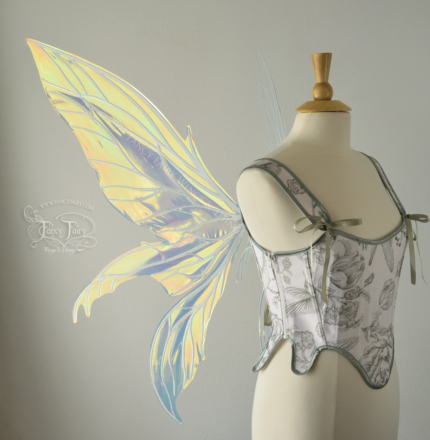 Large transparent yellow/orange/green iridescent fairy wings with white veins. Upper panels are elongated with pointed tips, 2 lower panels curve downward, worn on a dress form, left side view