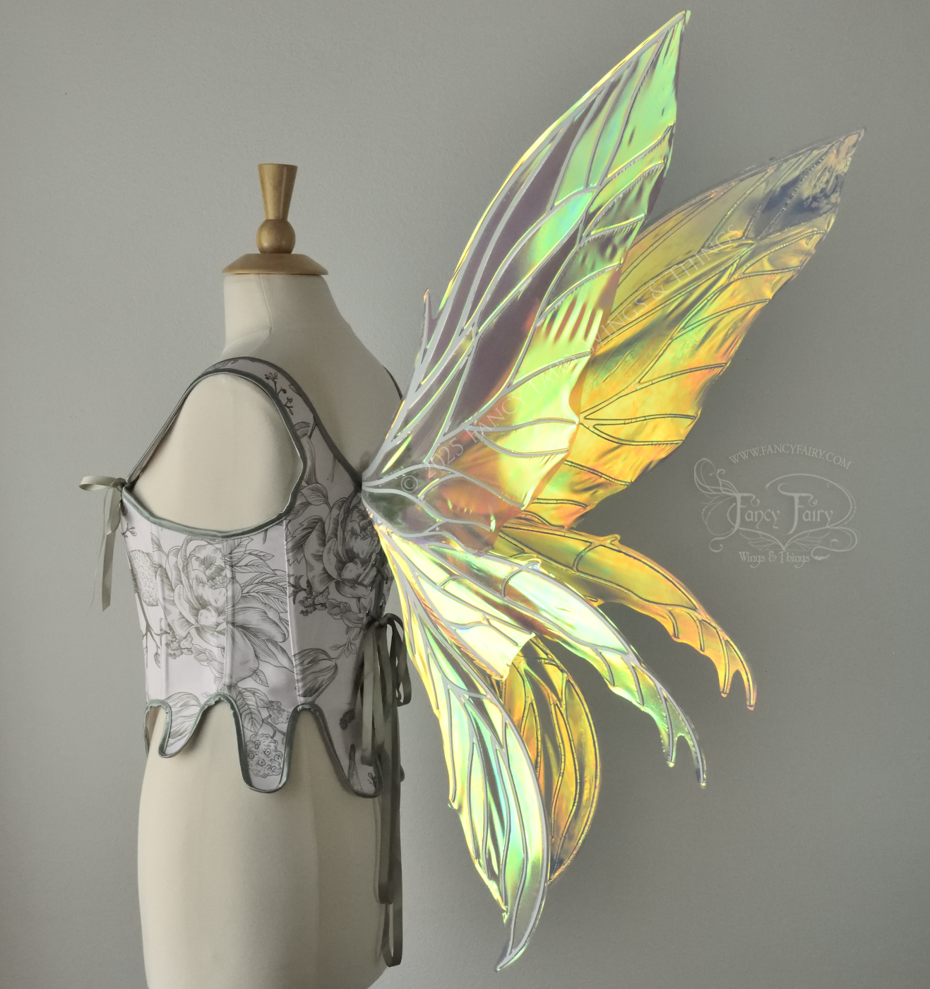Large transparent yellow/orange/green iridescent fairy wings with white veins. Upper panels are elongated with pointed tips, 2 lower panels curve downward, worn on a dress form, back 3/4 view