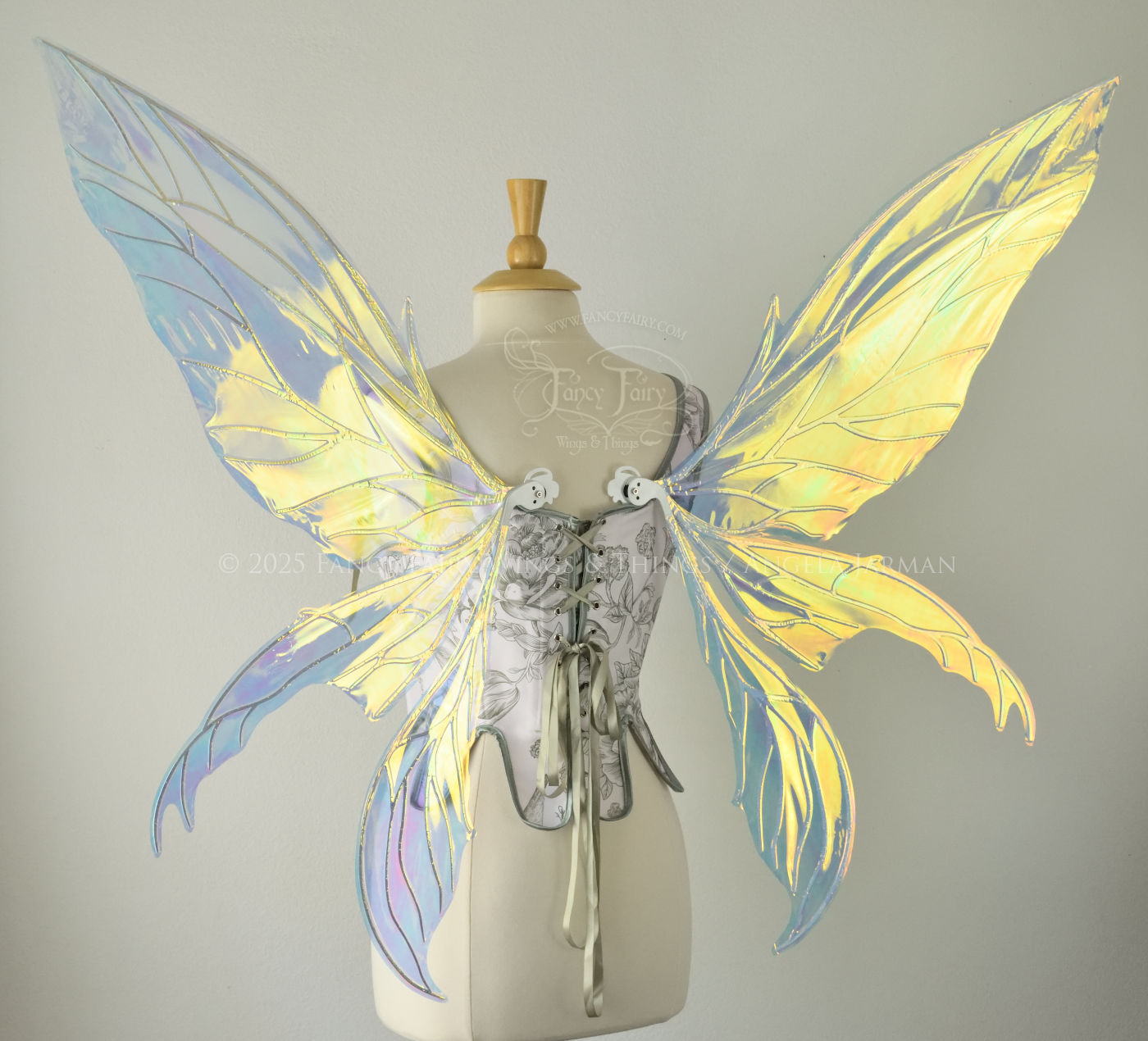 Large transparent yellow/orange/green iridescent fairy wings with white veins. Upper panels are elongated with pointed tips, 2 lower panels curve downward, worn on a dress form, back view