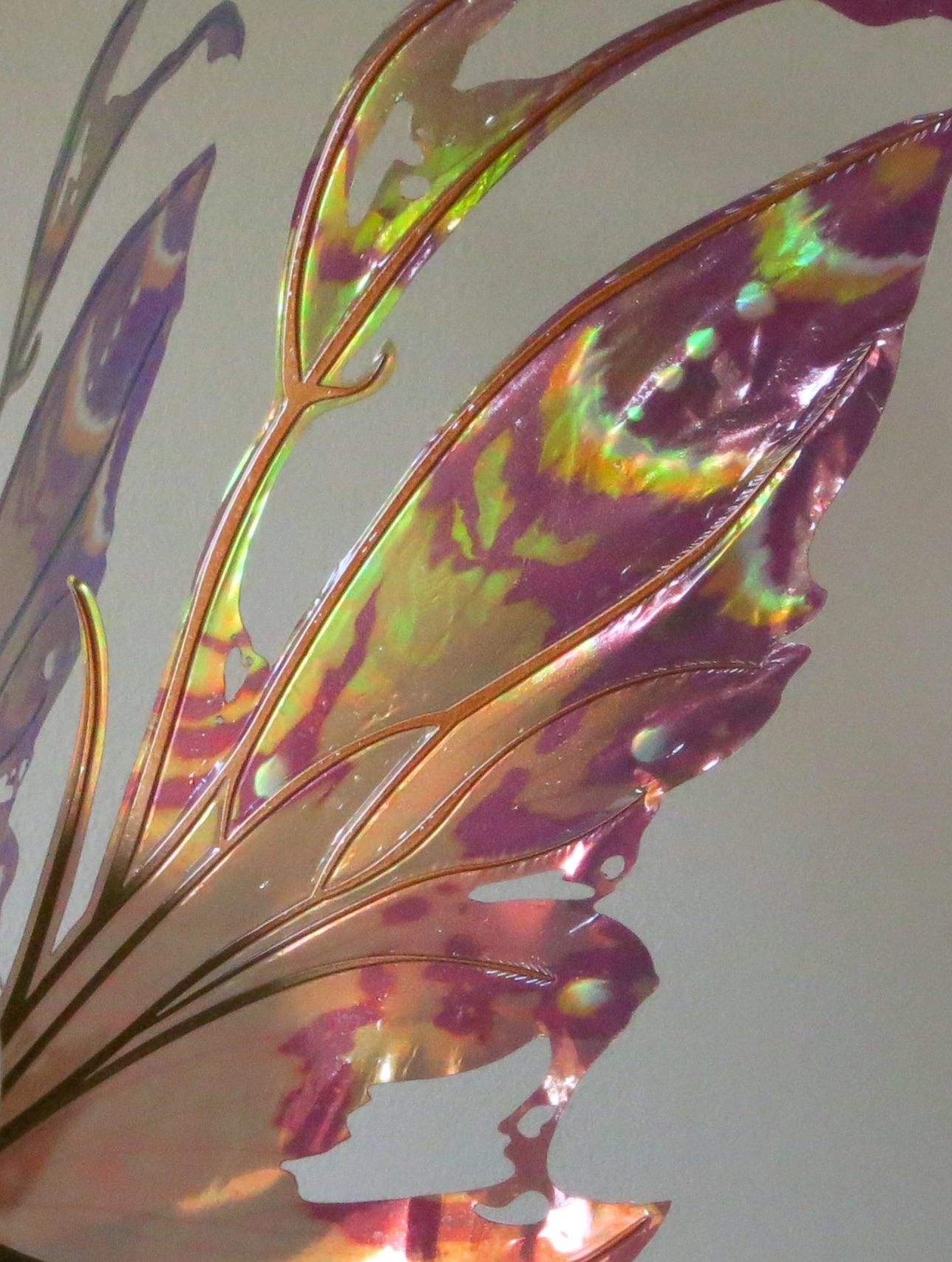 Close up of Kira wings in warm fall colors, muted plum, copper and green