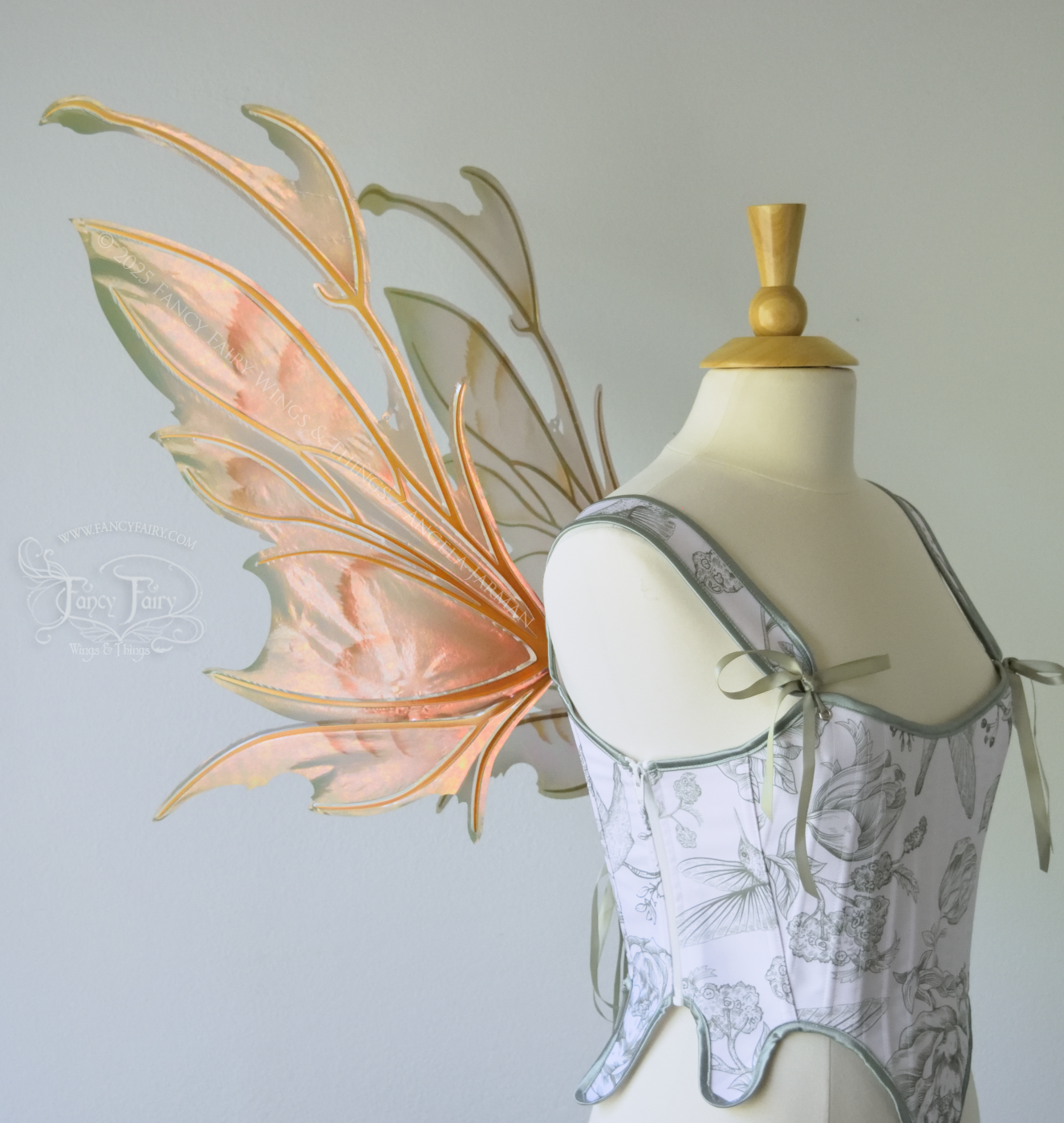 Rose Gold iridescent fairy wings with antennae and brown & olive green accents, copper veins, worn on a dress form, left side view