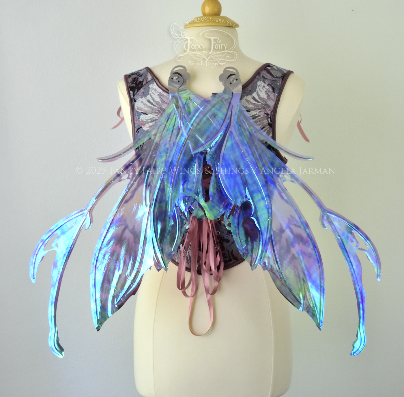 Purple & blue iridescent fairy wings with a spikey profile and antennae, with silver veins, are viewed from the back in resting position, worn on a dress form
