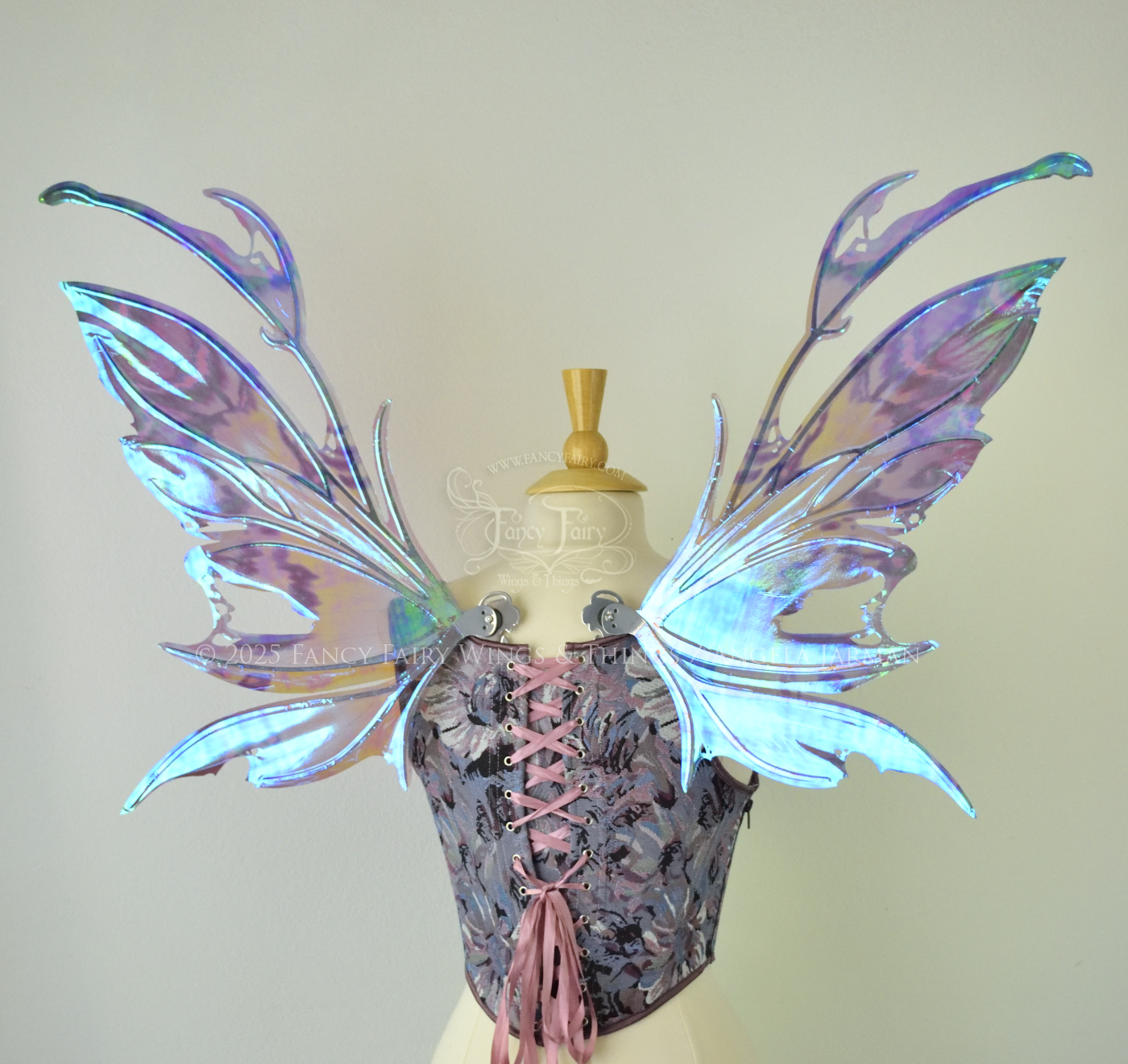 Purple & blue iridescent fairy wings with a spikey profile and antennae, with silver veins, are viewed from the back, worn on a dress form