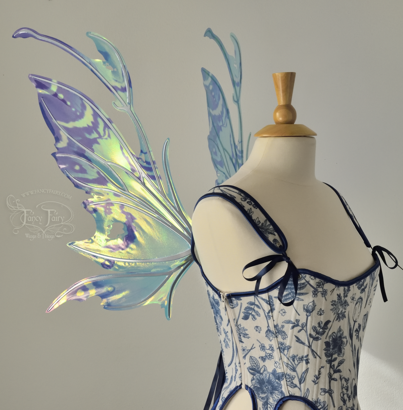 Teal, blue and silver iridescent fairy wings with a spikey profile and antennae, left side view, worn on a dress form