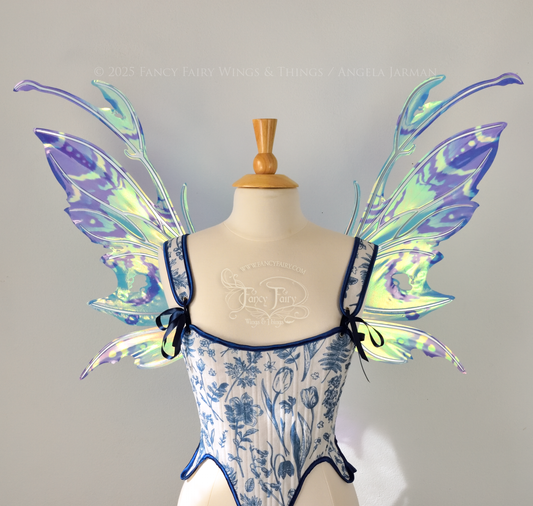 Teal, blue and silver iridescent fairy wings with a spikey profile and antennae are viewed from the front, worn on a dress form