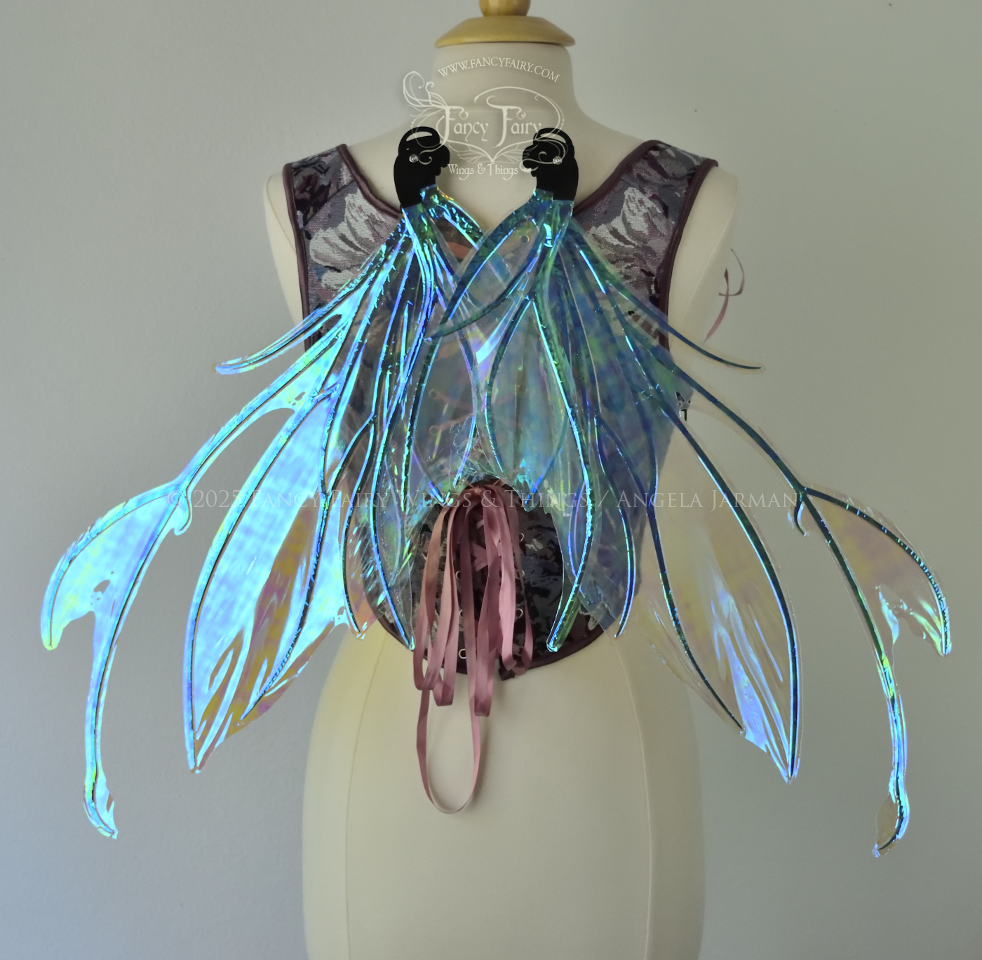 Iridescent & transparent blue fairy wings with black veins and antennae, worn on a dress form, back view in resting position