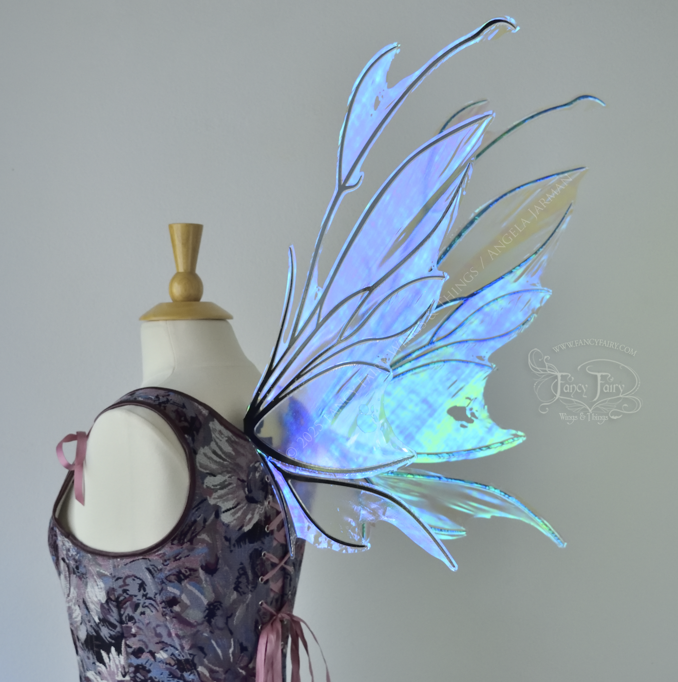 Iridescent & transparent blue fairy wings with black veins and antennae, worn on a dress form, back 3/4 view