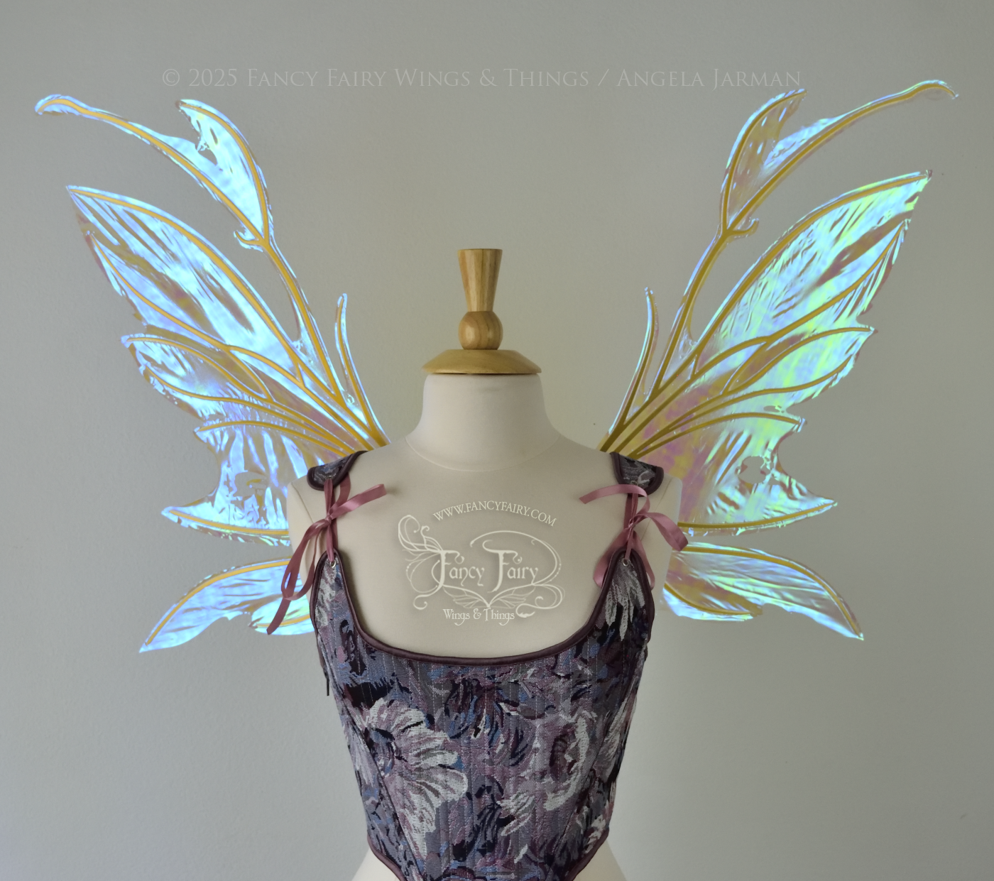 Transparent blue / green iridescent fairy wings with antennae and tattered holes with gold veins, worn on a dress form, front view