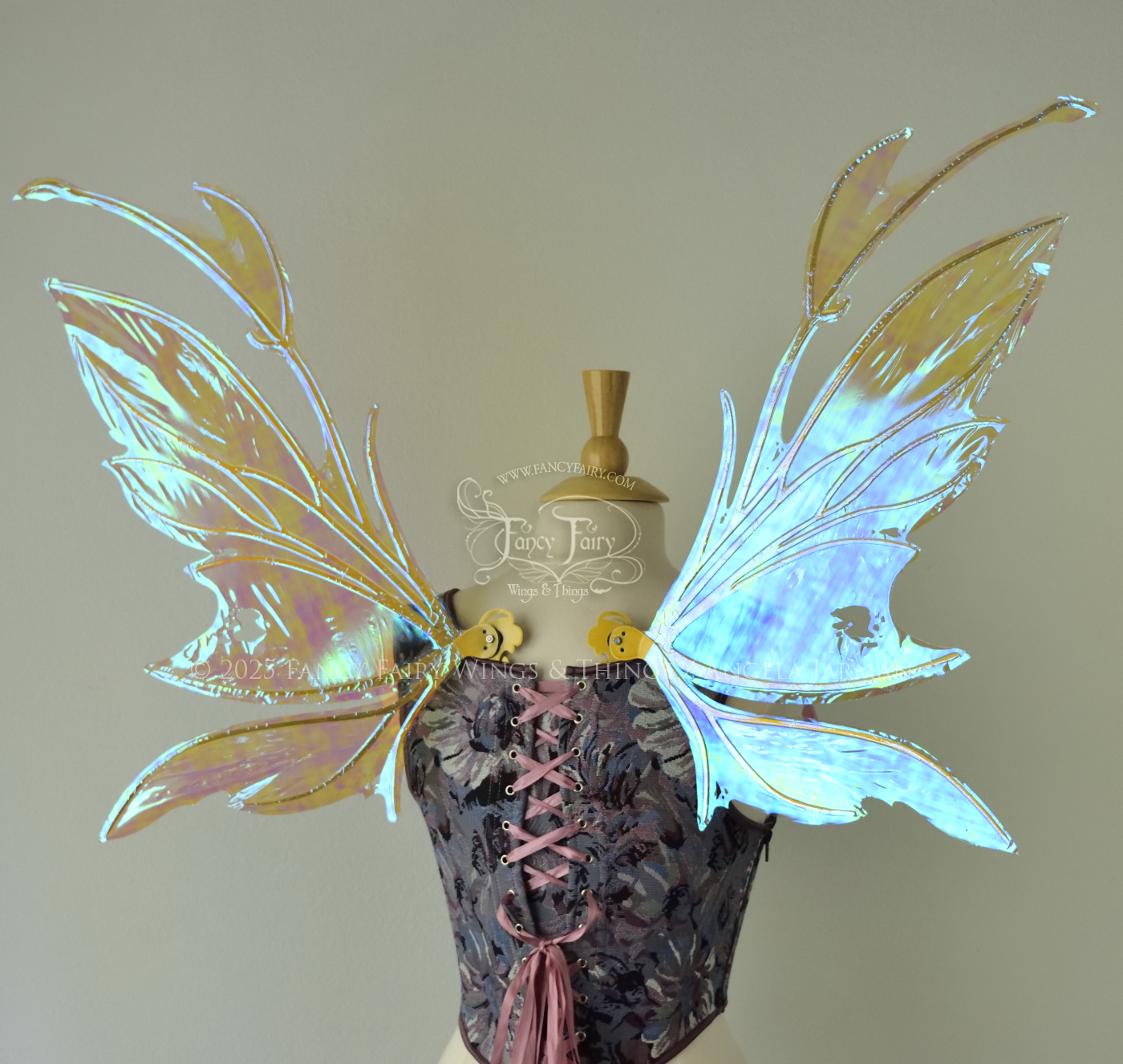 Transparent blue / green iridescent fairy wings with antennae and tattered holes with gold veins, worn on a dress form, back view