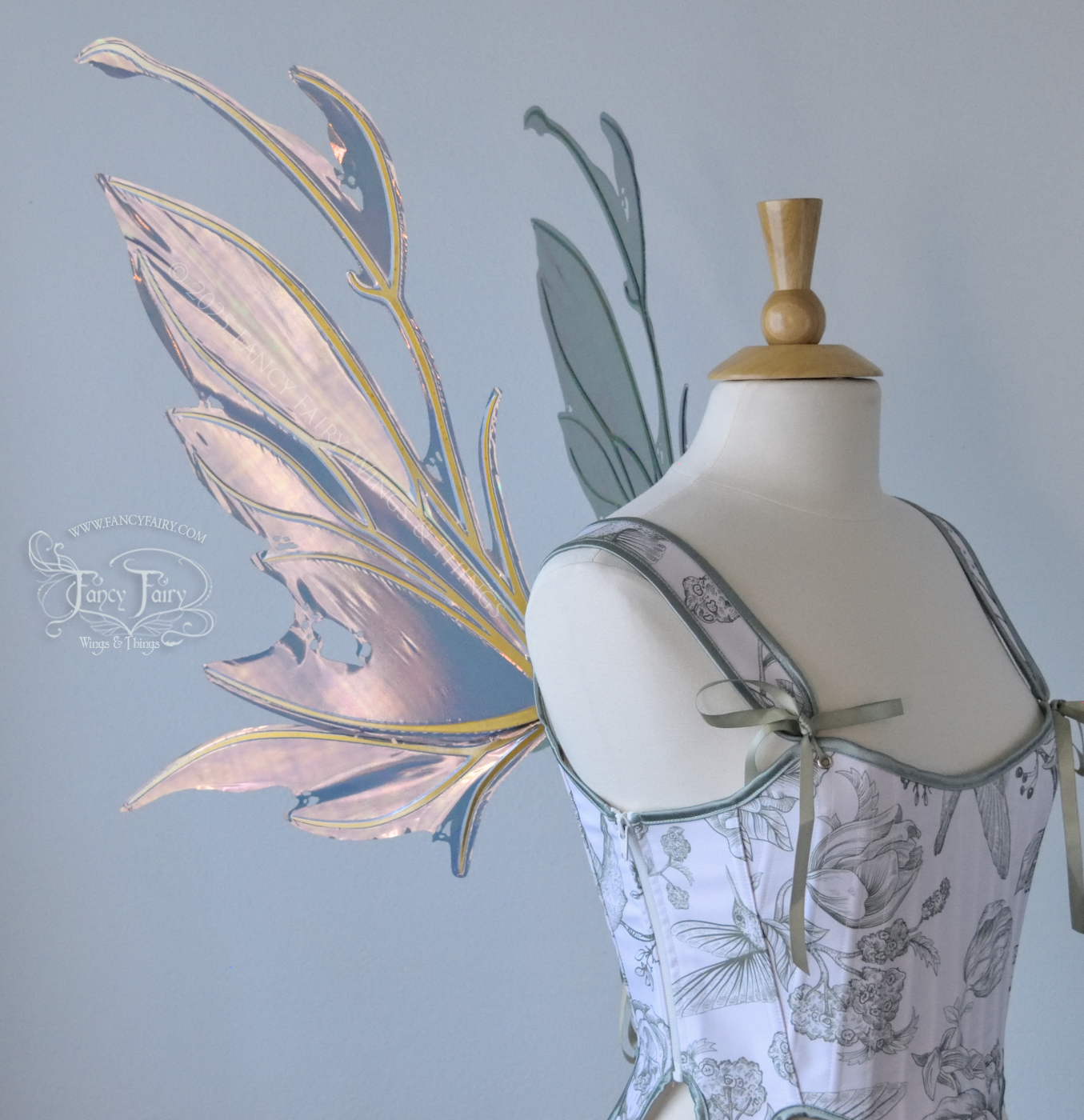Dark orange / green & grey iridescent fairy wings with antennae and a spikey silhouette with tattered holes and gold veins, worn on a dress form, left side view