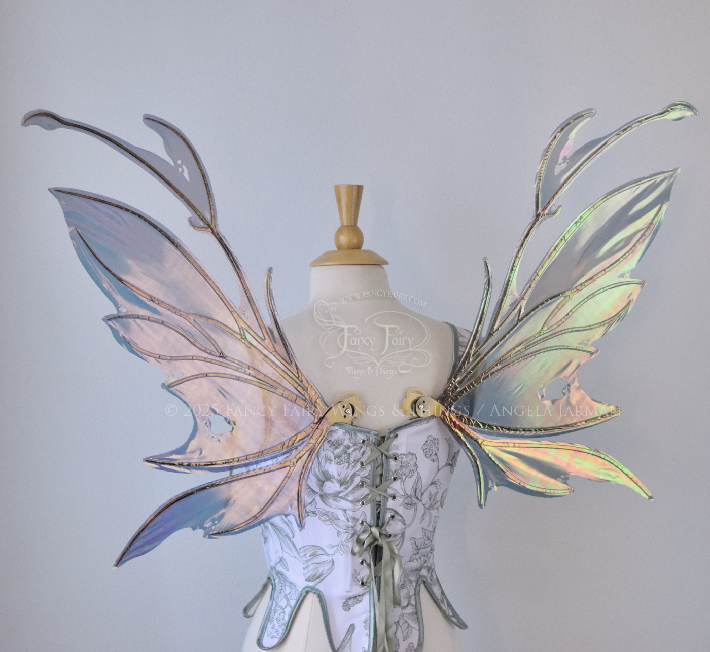 Dark orange / green & grey iridescent fairy wings with antennae and a spikey silhouette with tattered holes and gold veins, worn on a dress form, back view