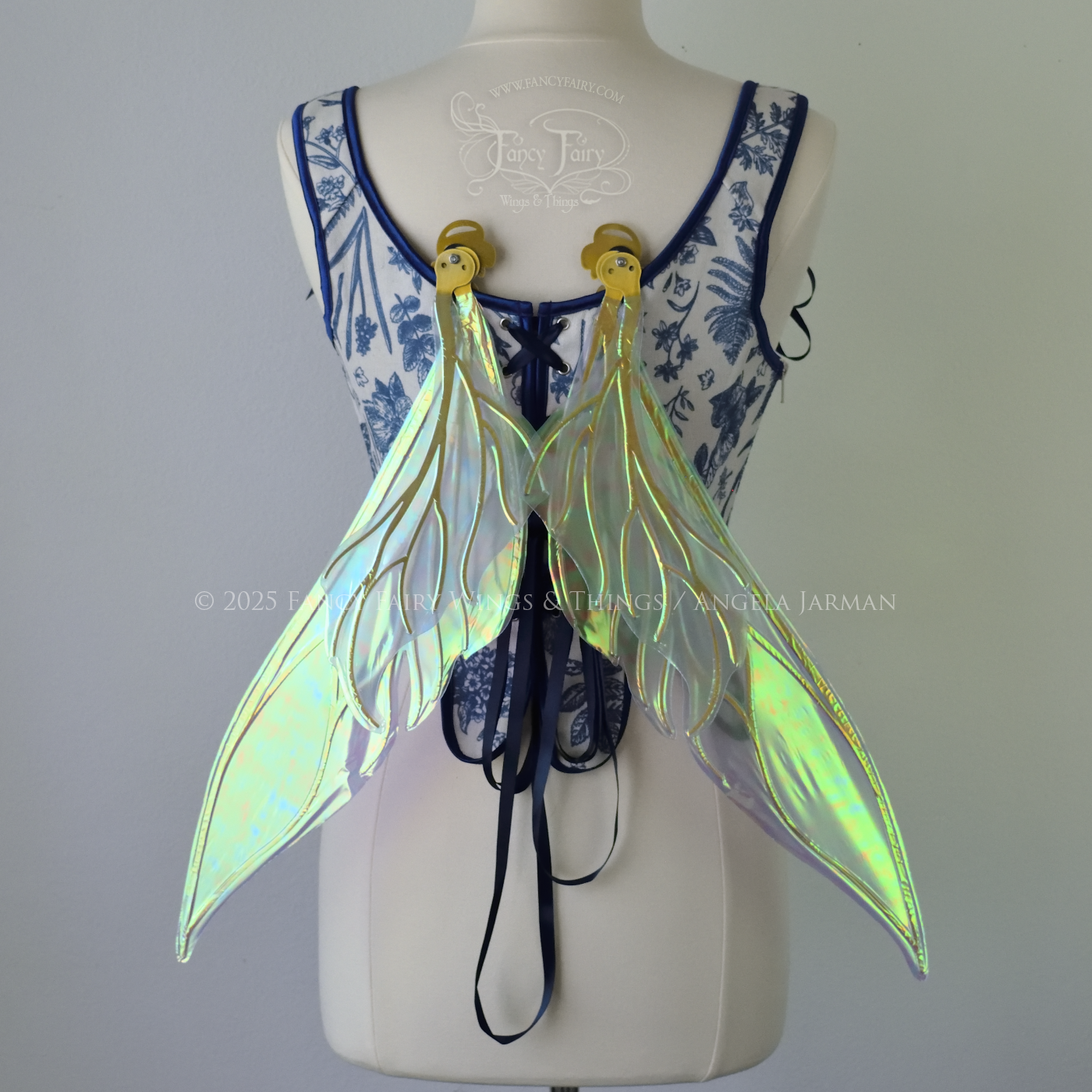 Iridescent blue / green fairy wings with elongated pointy upper panels and small leaf like lower panels, with gold veins, back view, in resting position