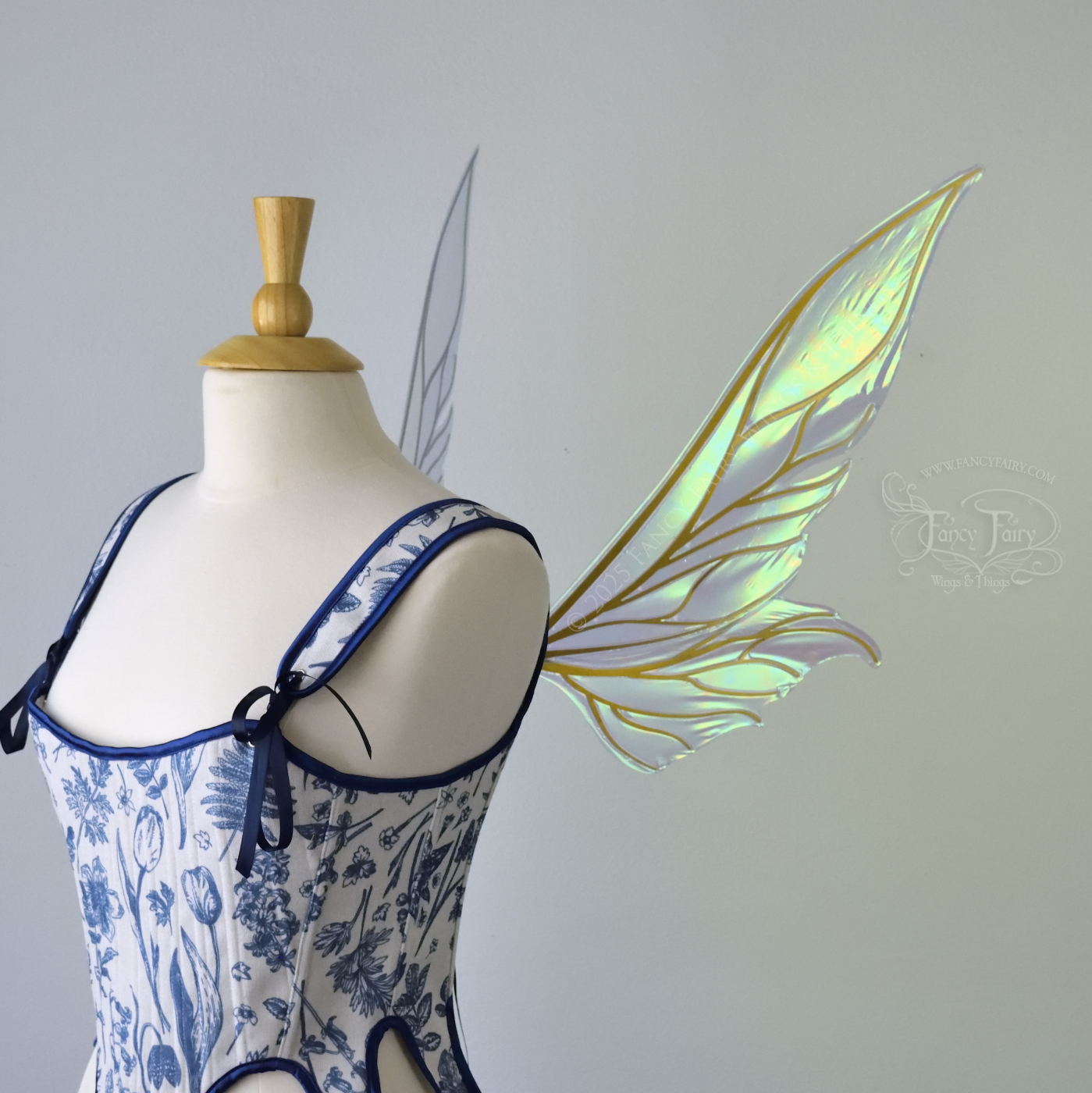 Iridescent blue / green fairy wings with elongated pointy upper panels and small leaf like lower panels, with gold veins, right side view