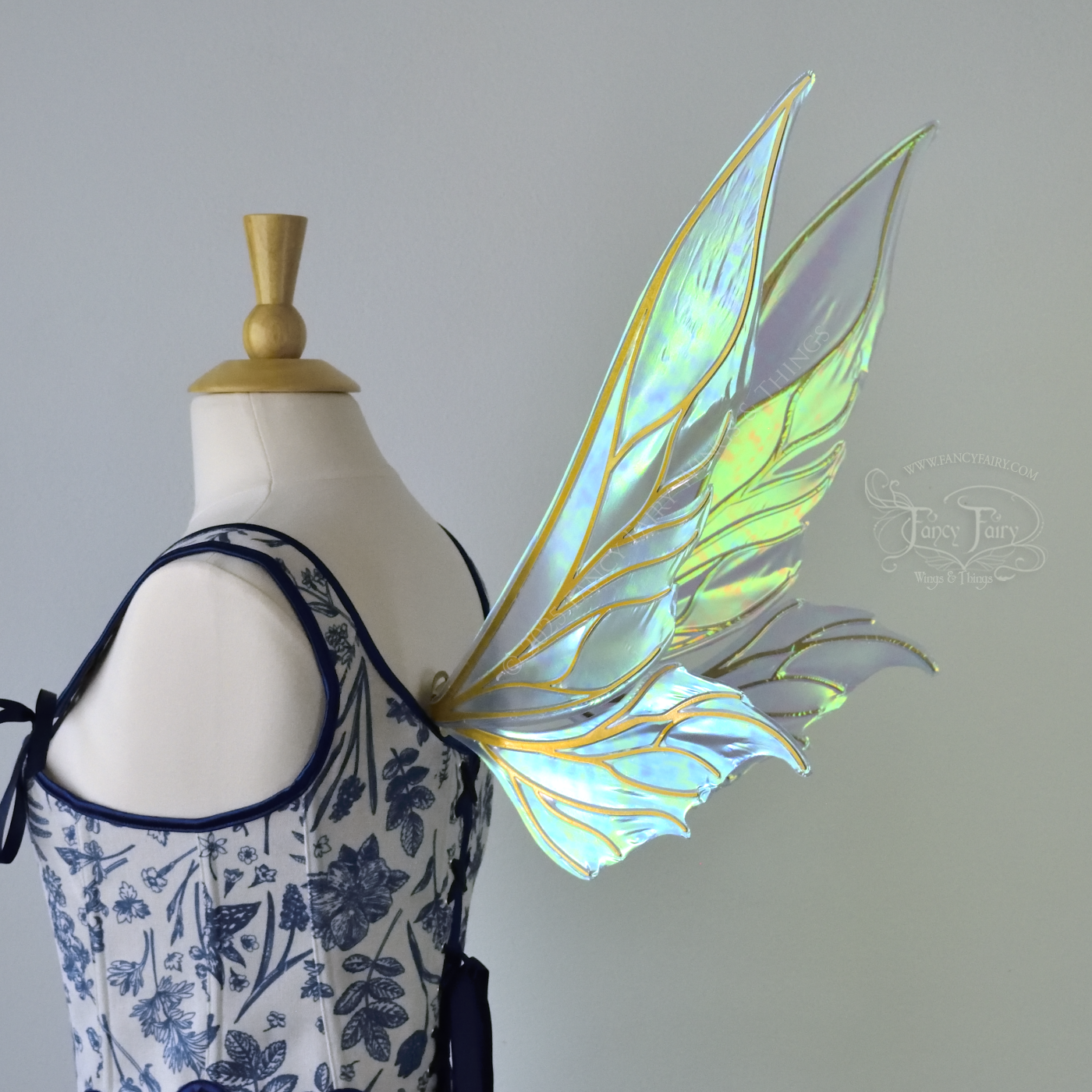 Iridescent blue / green fairy wings with elongated pointy upper panels and small leaf like lower panels, with gold veins, 3/4 back right side view
