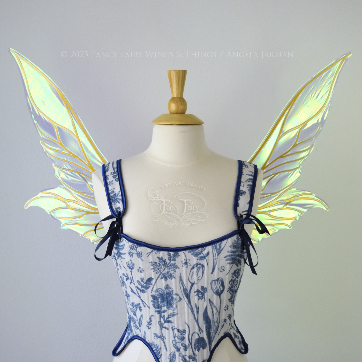 Iridescent blue / green fairy wings with elongated pointy upper panels and small leaf like lower panels, with gold veins, front view