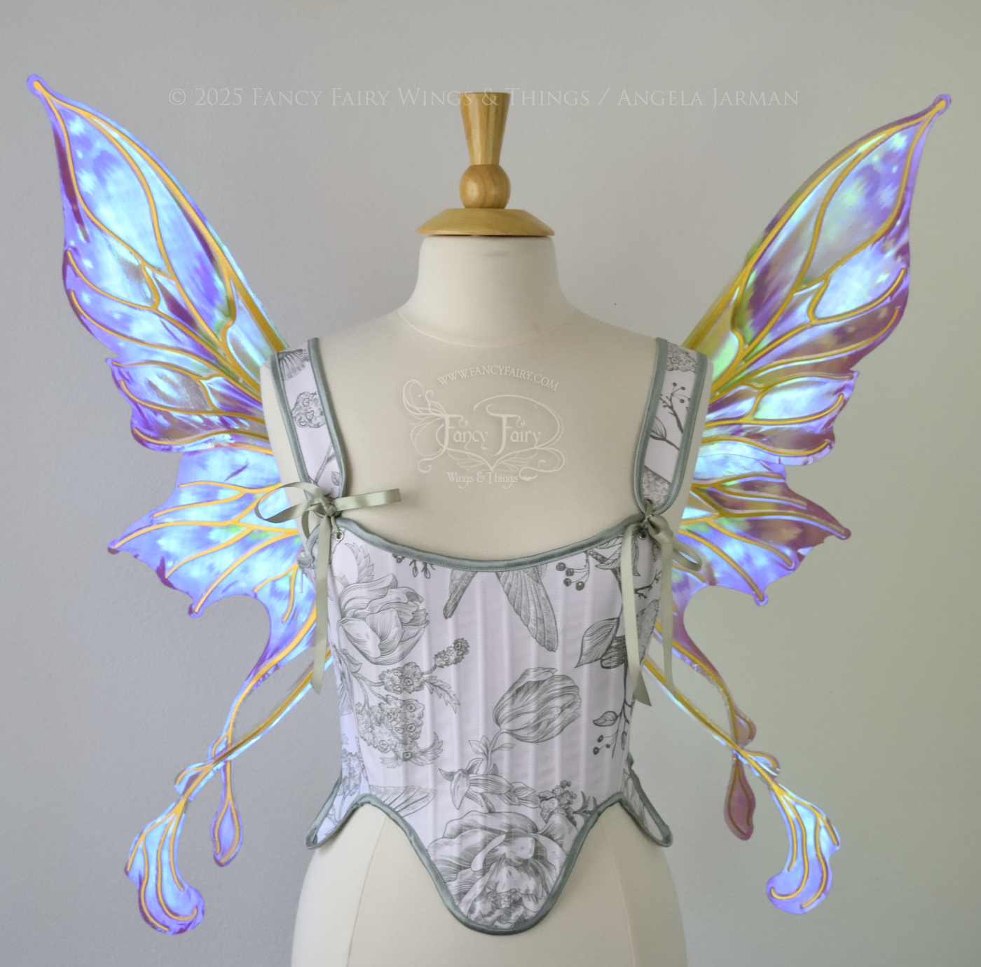 Iridescent & transparent purple & green fairy wings with gold veins and 2 swirling tails, worn on a dress form, front view