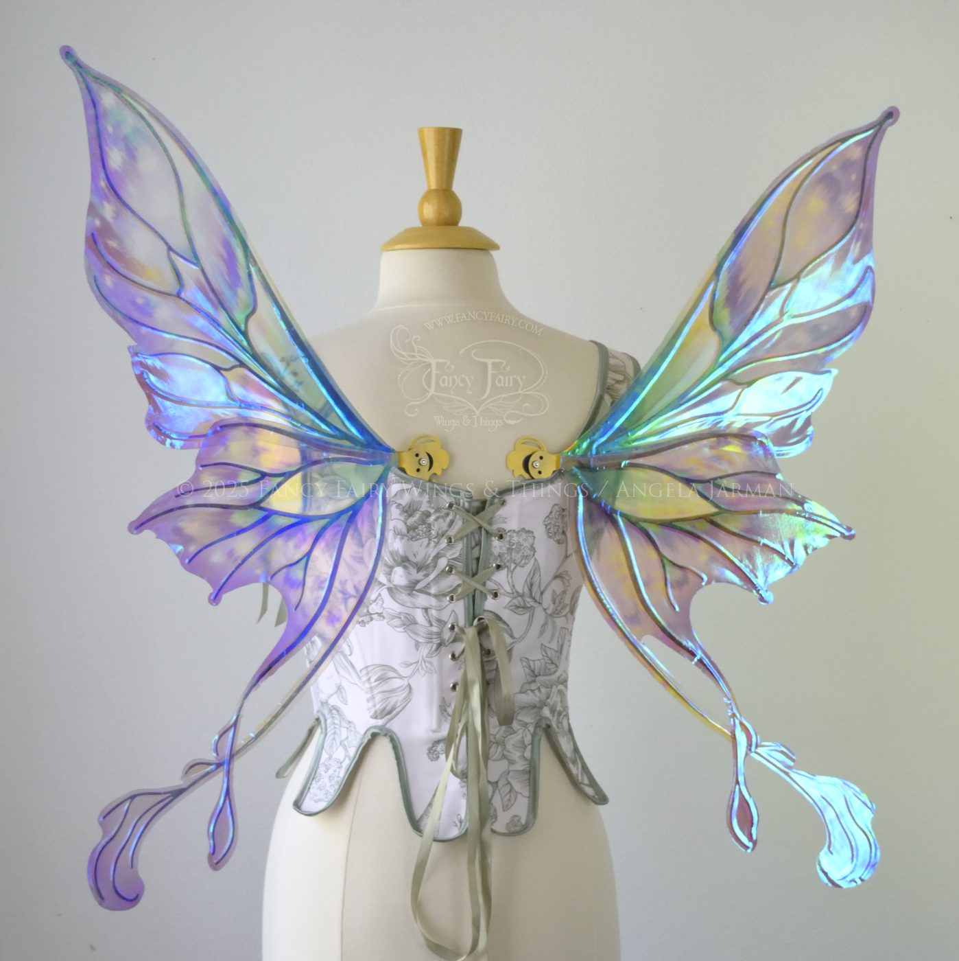 Iridescent & transparent purple & green fairy wings with gold veins and 2 swirling tails, worn on a dress form, back view