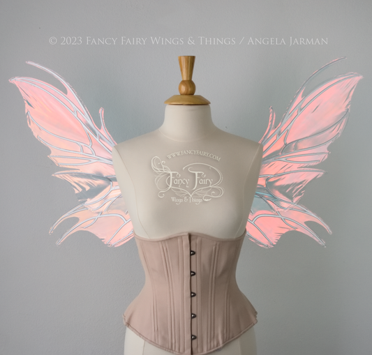 Front view of a dress form wearing an underbust corset & pink iridescent fairy wings with a spikey shape, with silver veins