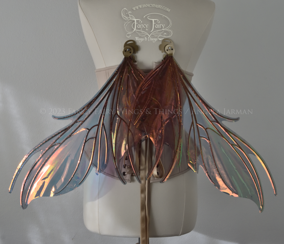 Back view of iridescent orange & dark grey/blue fairy wings with spikey veins, in resting position, worn by a dress form