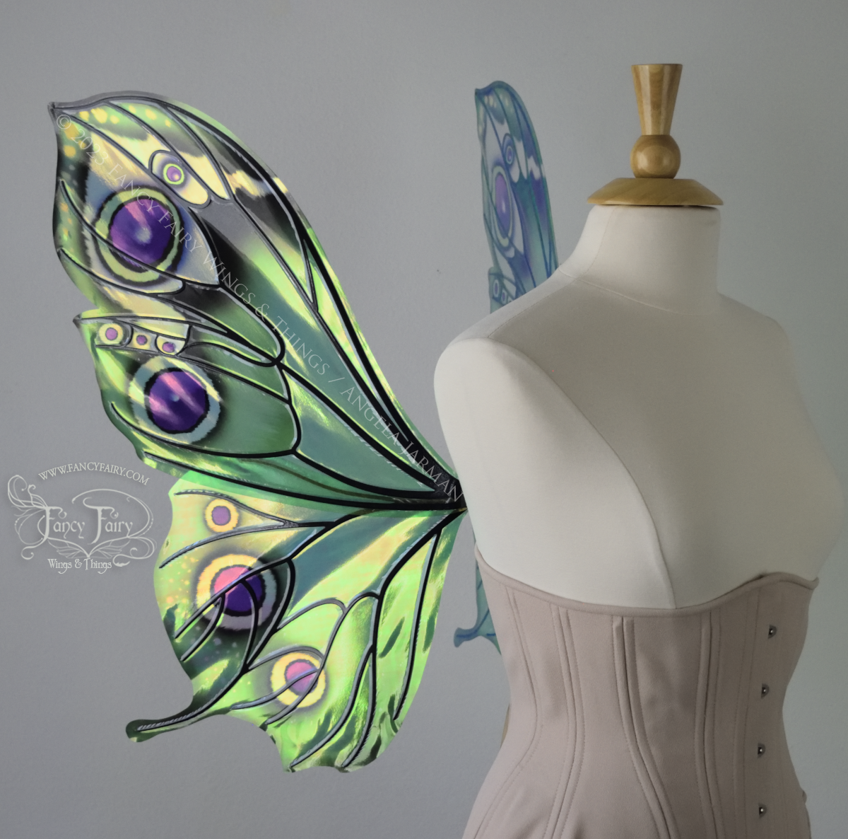 Left side view of iridescent green, black and fuchsia costume fairy wings, worn on a dressform