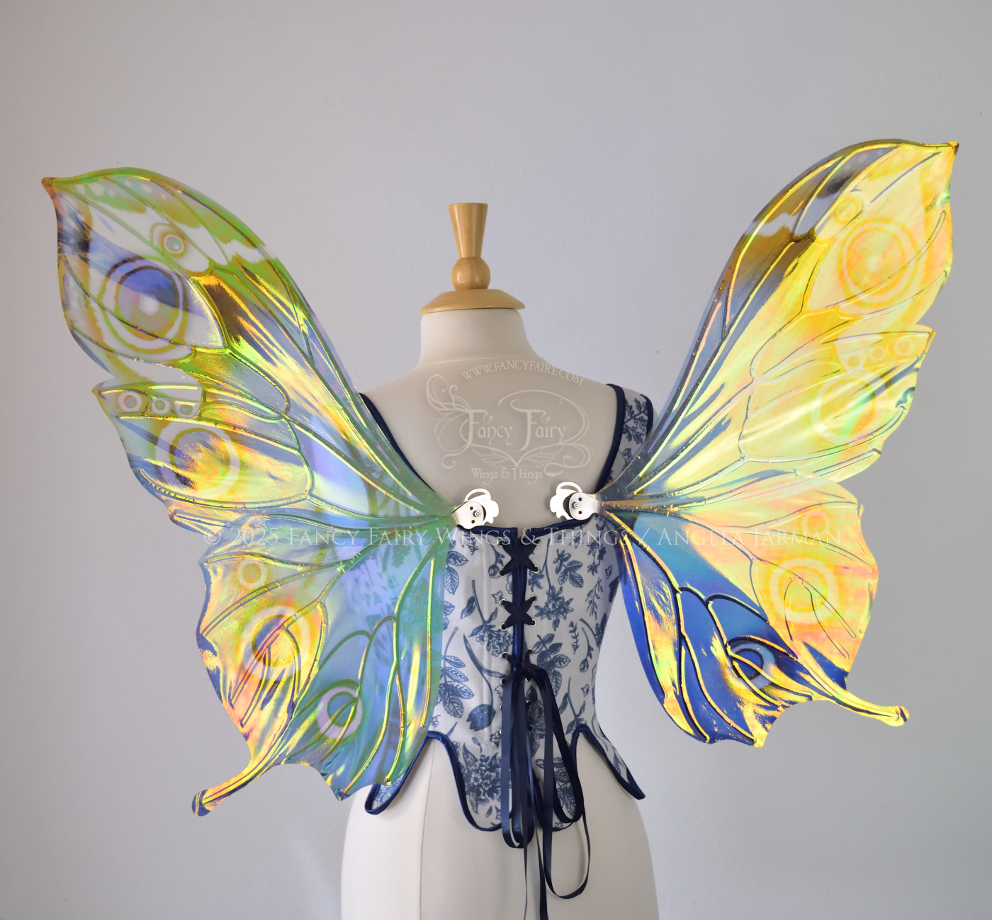 Blue iridescent butterfly shaped fairy wings with markings & 'eye' spots like the Buckeye butterfly, with silver veins, worn on a dress form, back view