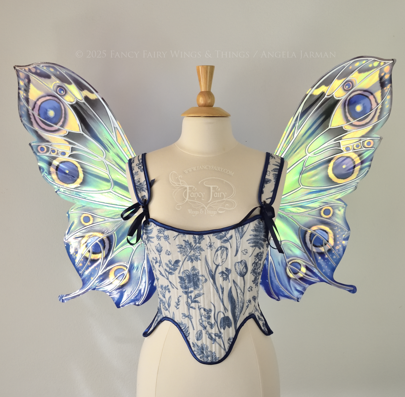 Blue iridescent butterfly shaped fairy wings with markings & 'eye' spots like the Buckeye butterfly, with silver veins, worn on a dress form, front view