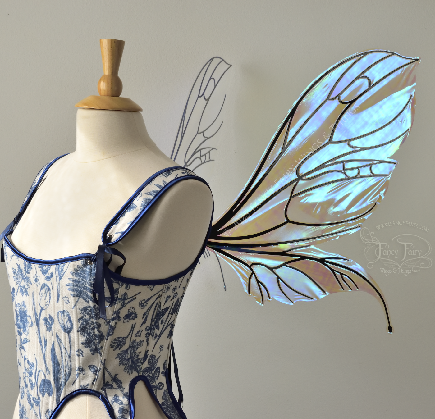 Large transparent iridescent blue fairy wings with black veins, worn on a dress form, right side view