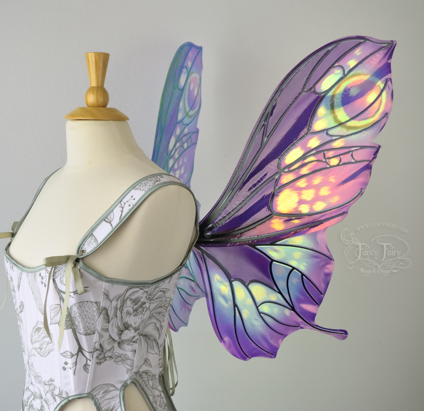 Iridescent fairy wings with a butterfly-like shape and short 'tails' in purples & blues with touches of pink & orange, right side view