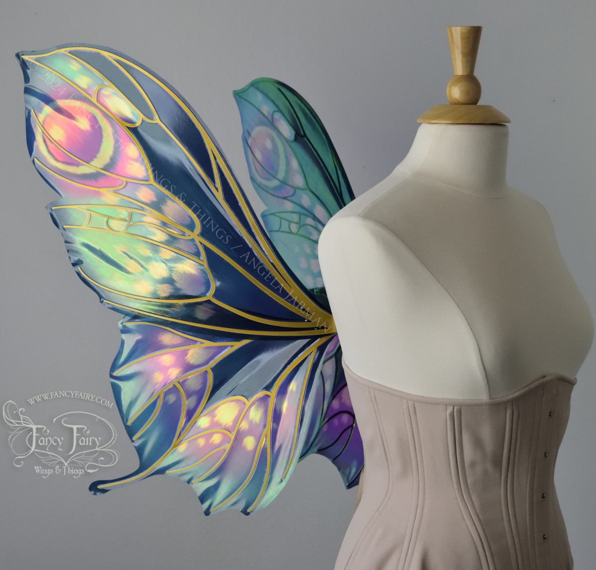 Left side view of butterfly shaped iridescent wings in shades of teal with pink and lavender accents with gold veins, worn on a dressform
