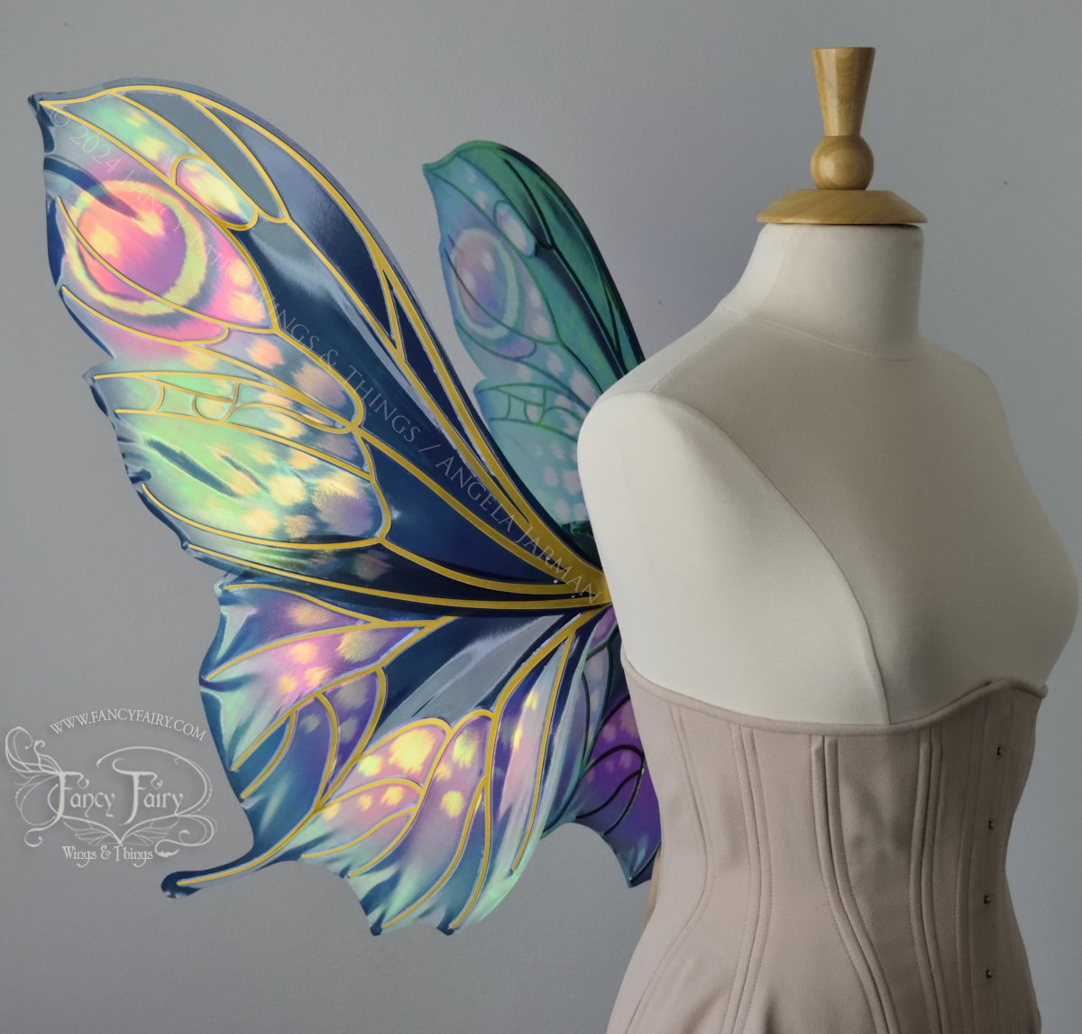 Left side view of butterfly shaped iridescent wings in shades of teal with pink and lavender accents with gold veins, worn on a dressform