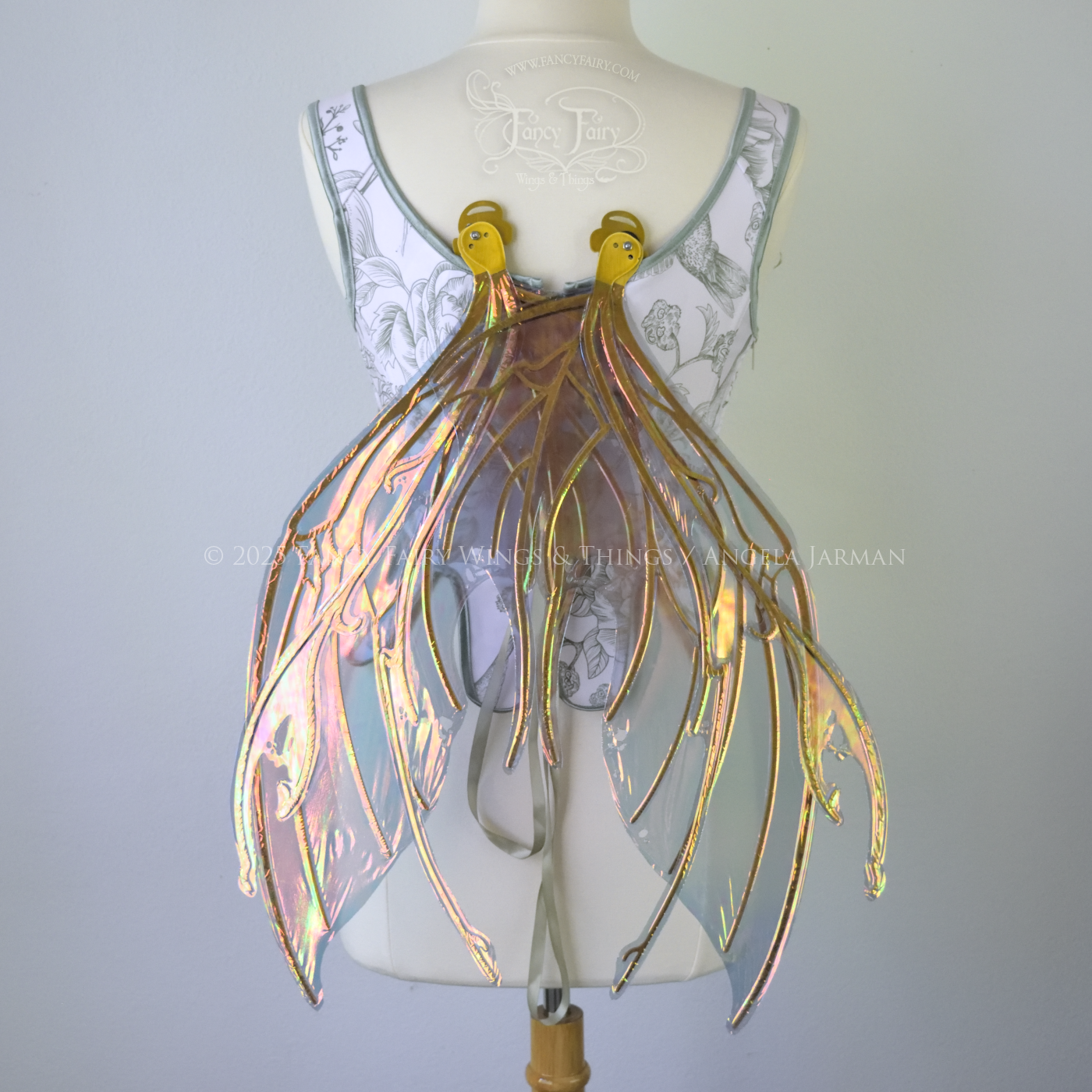 Beetle inspired iridescent orange, green & grey costume wings with antennae and gold veins, worn on a dress form, back view, in resting position
